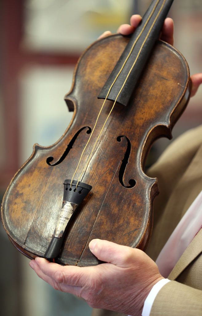 A man holding up a violin. | Source: Shutterstock