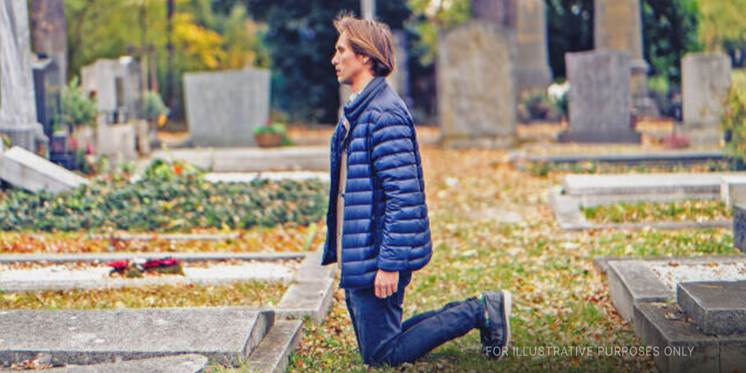 Man sitting over a grave in a cemetery. | Source: Shutterstock