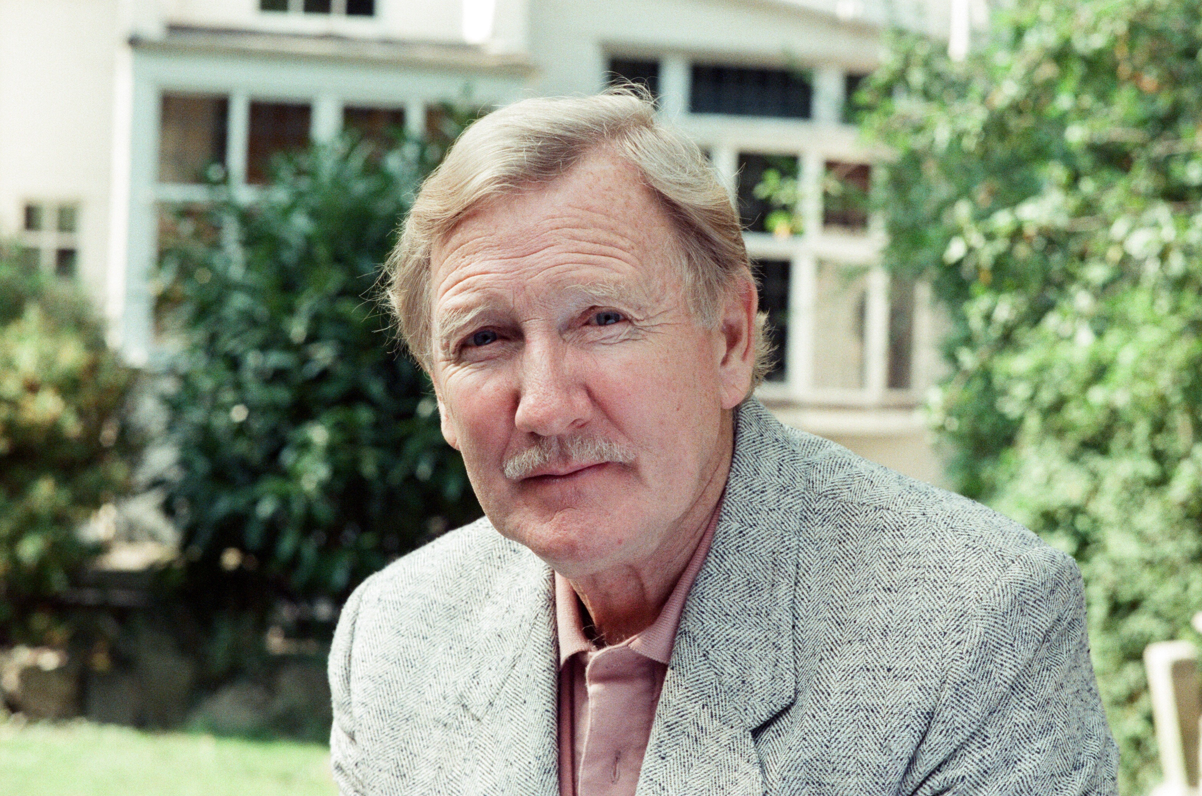 Leslie Phillips posing for a photo on September 18, 1989 | Source: Getty Images