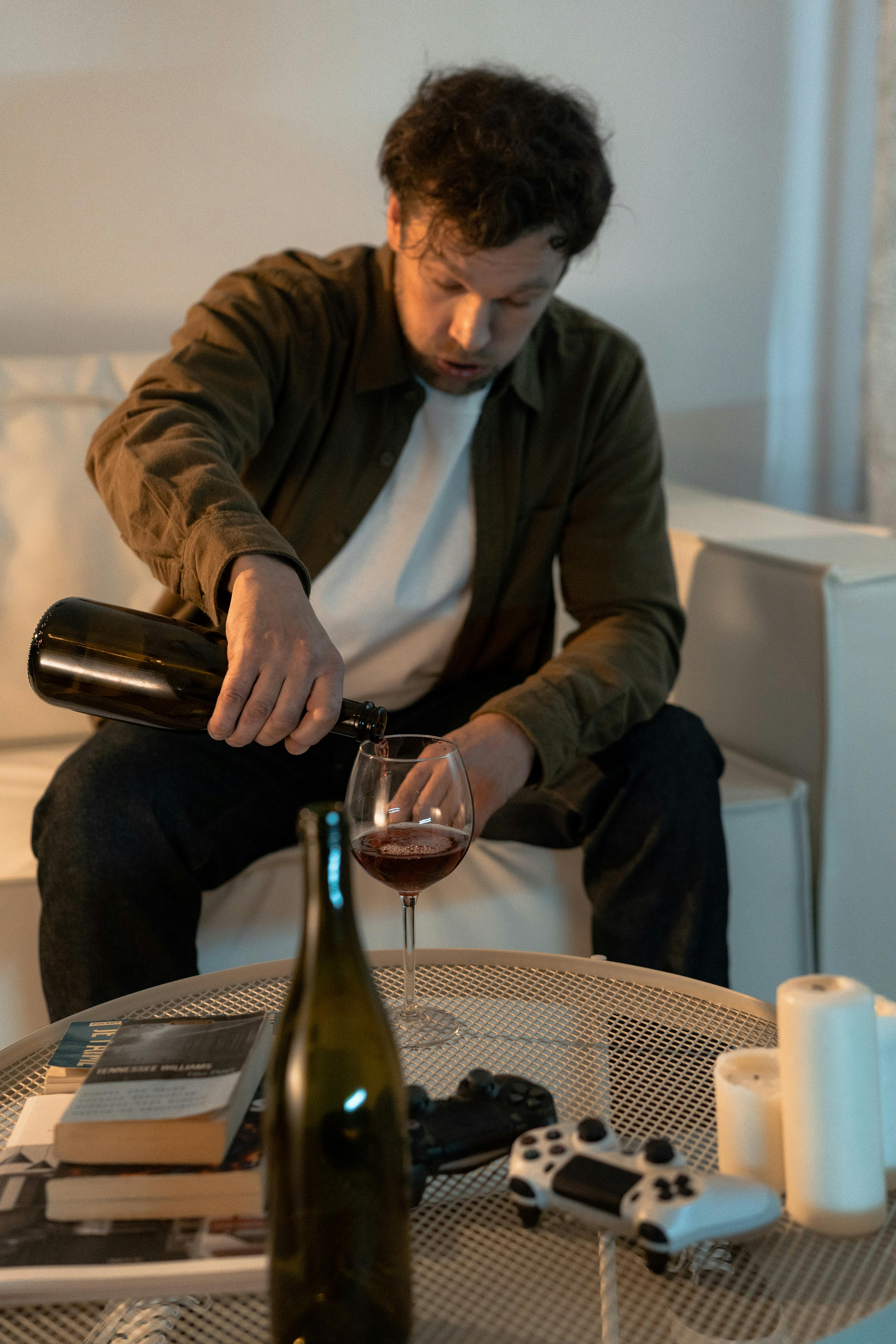 A drunk man pouring himself some wine | Source: Pexels