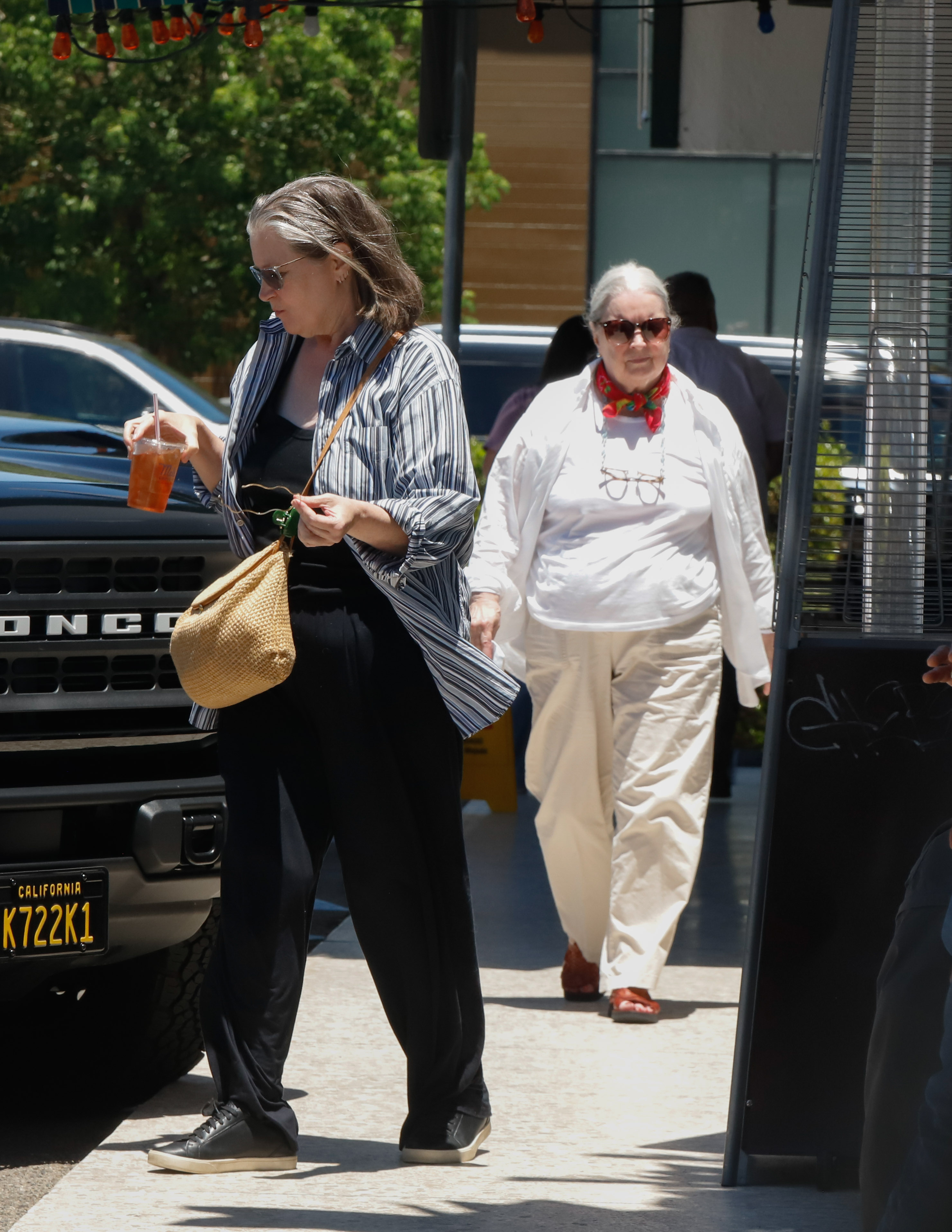 Continuing her day out in Los Angeles, Fonda was photographed holding an iced drink while walking past a row of parked cars. Her laid-back look — complete with a slouchy woven bag and untucked shirt — reflected her effortless, off-duty style.