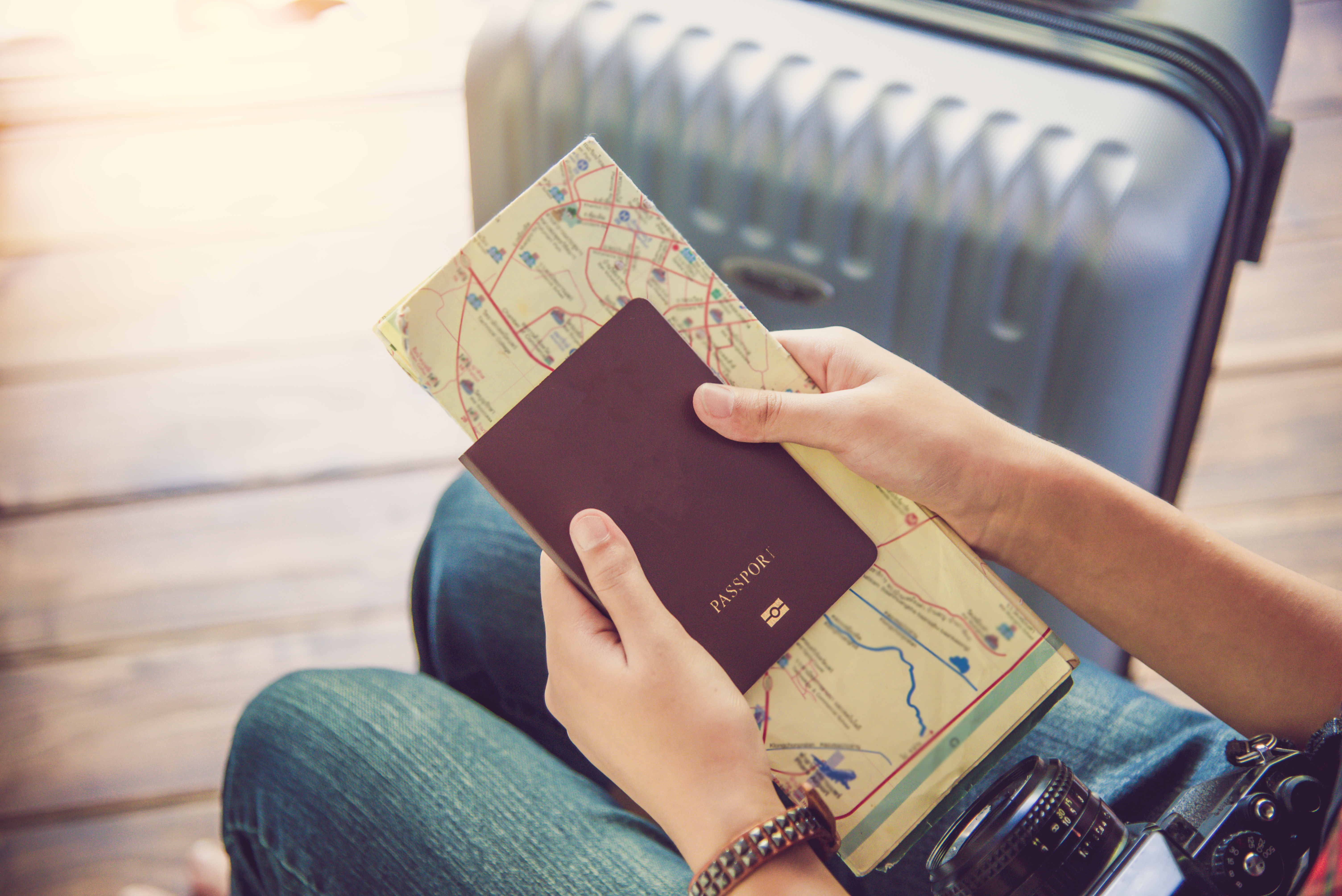 A person holding a passport and map | Source: Shutterstock