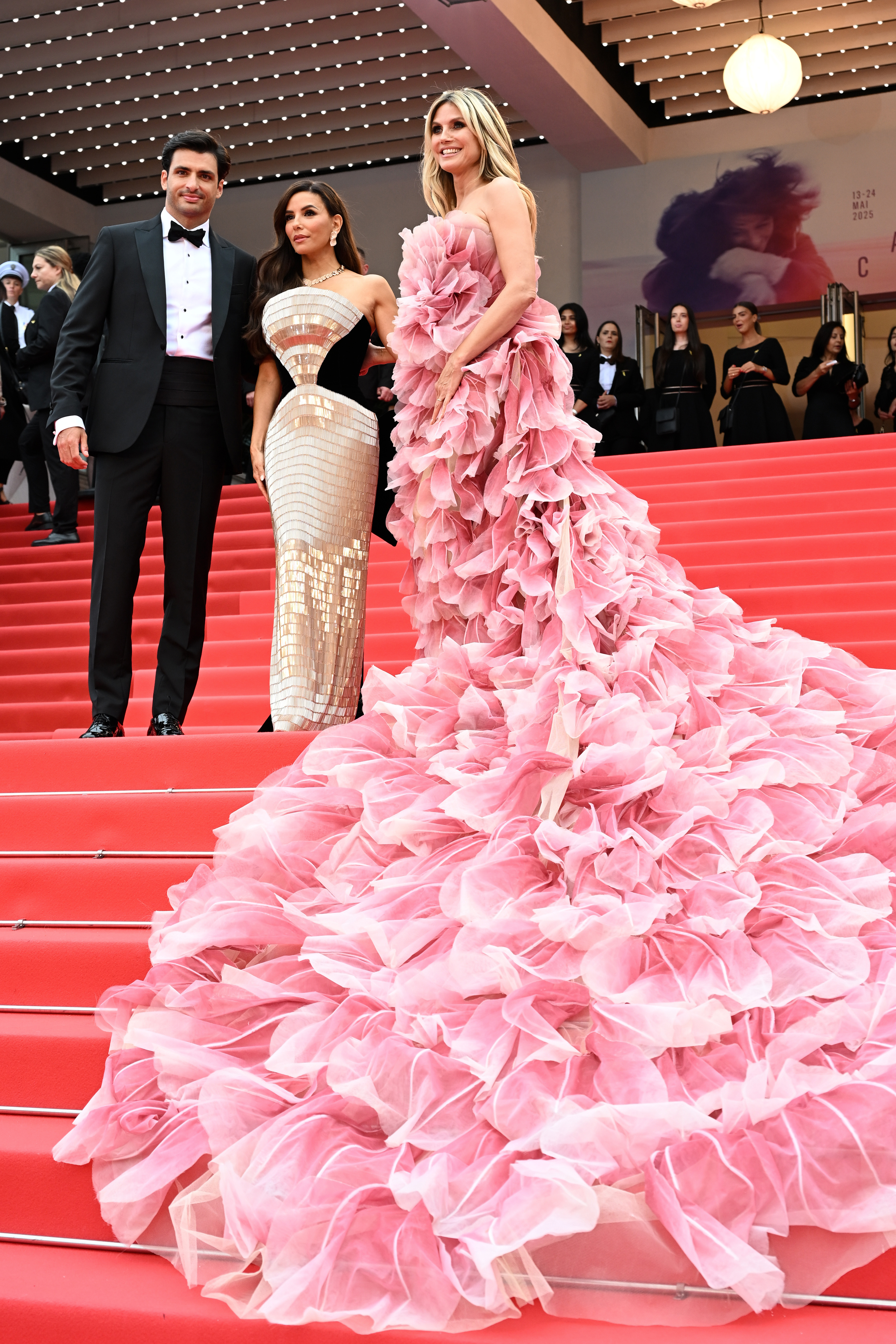 Beauty and handsomeness collide in one captivating shot as Klum poses on the stairs alongside a dashing Carlos Sainz Jr. and the ever-glamorous Eva Longoria — a trio that effortlessly lights up the picture.