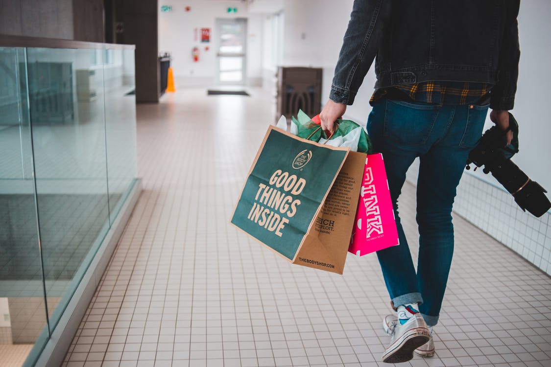 Hombre con bolsas de compras en un centro comercial. | Foto: Pexels