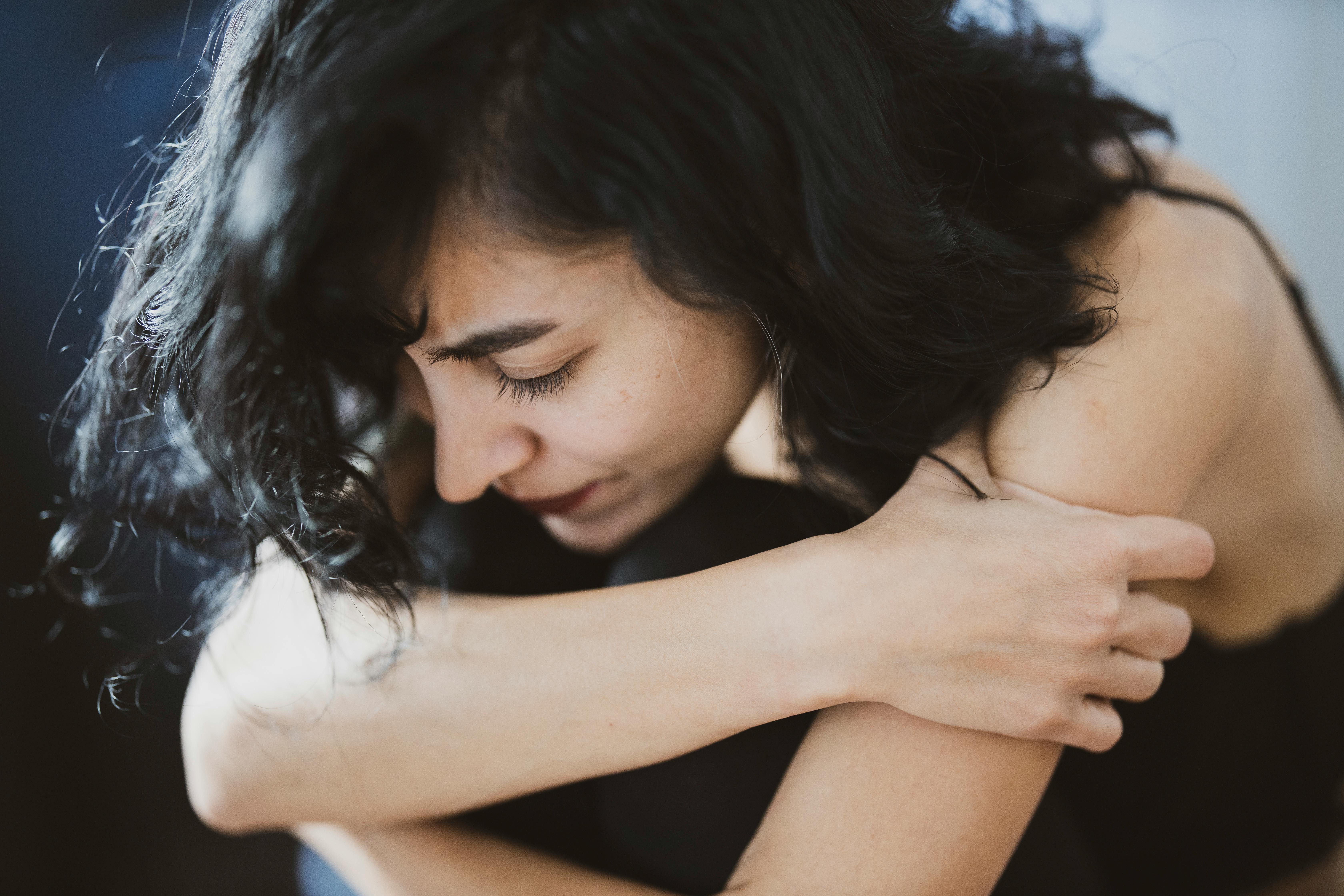 A sad woman embracing herself while seated | Source: Pexels