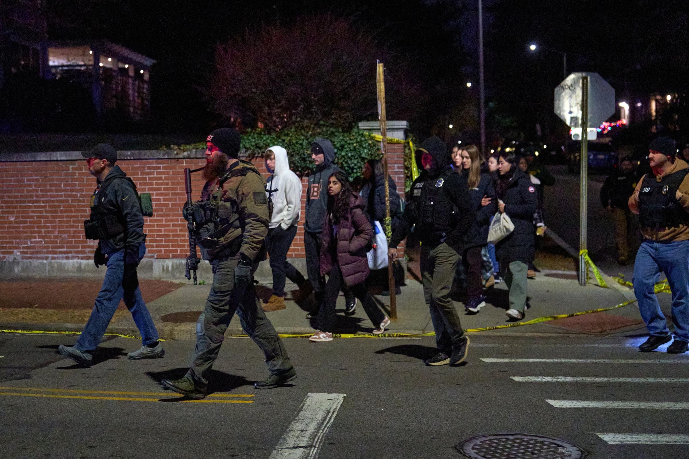 Law enforcement officers escort students near the Barus & Holley engineering building at Brown University campus on December 13, 2025, in Providence, Rhode Island | Source: Getty Images