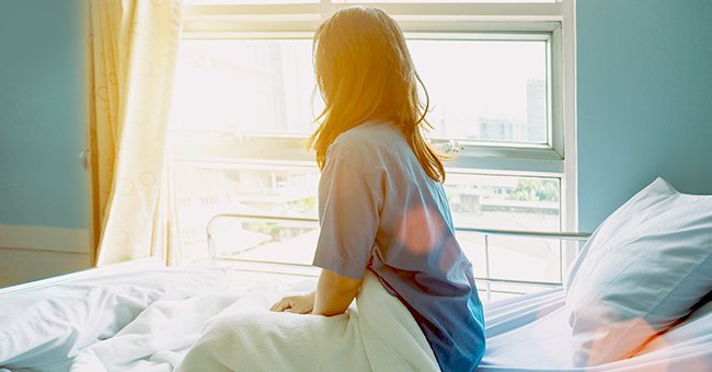 A photo of a woman sitting on a hospital bed. | Photo: Shutterstock