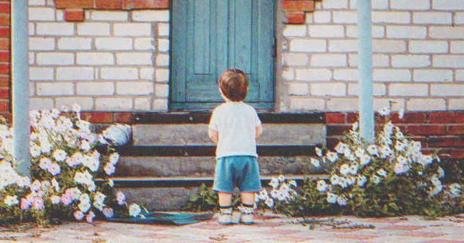 Un niño pequeño parado frente a la puerta de una casa. | Foto: Shutterstock
