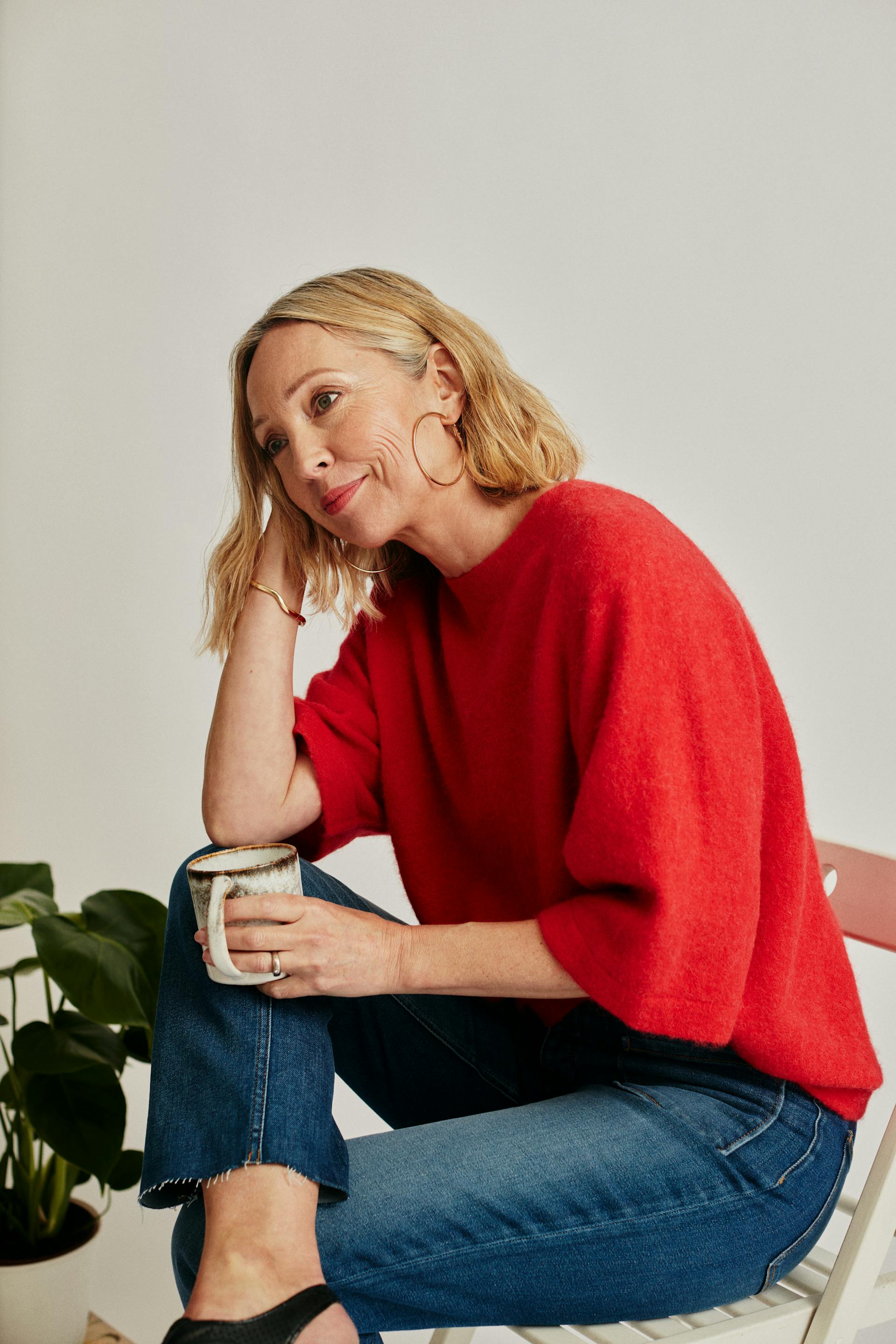A woman sitting on a chair with a white mug | Source: Pexels