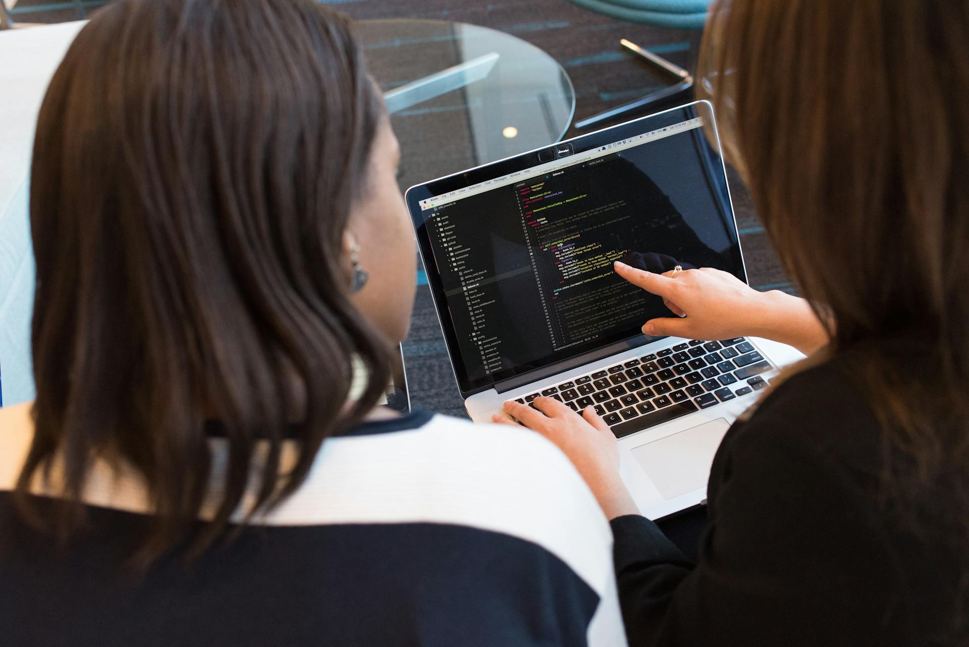 Two women looking at code on a laptop screen | Source: Pexels