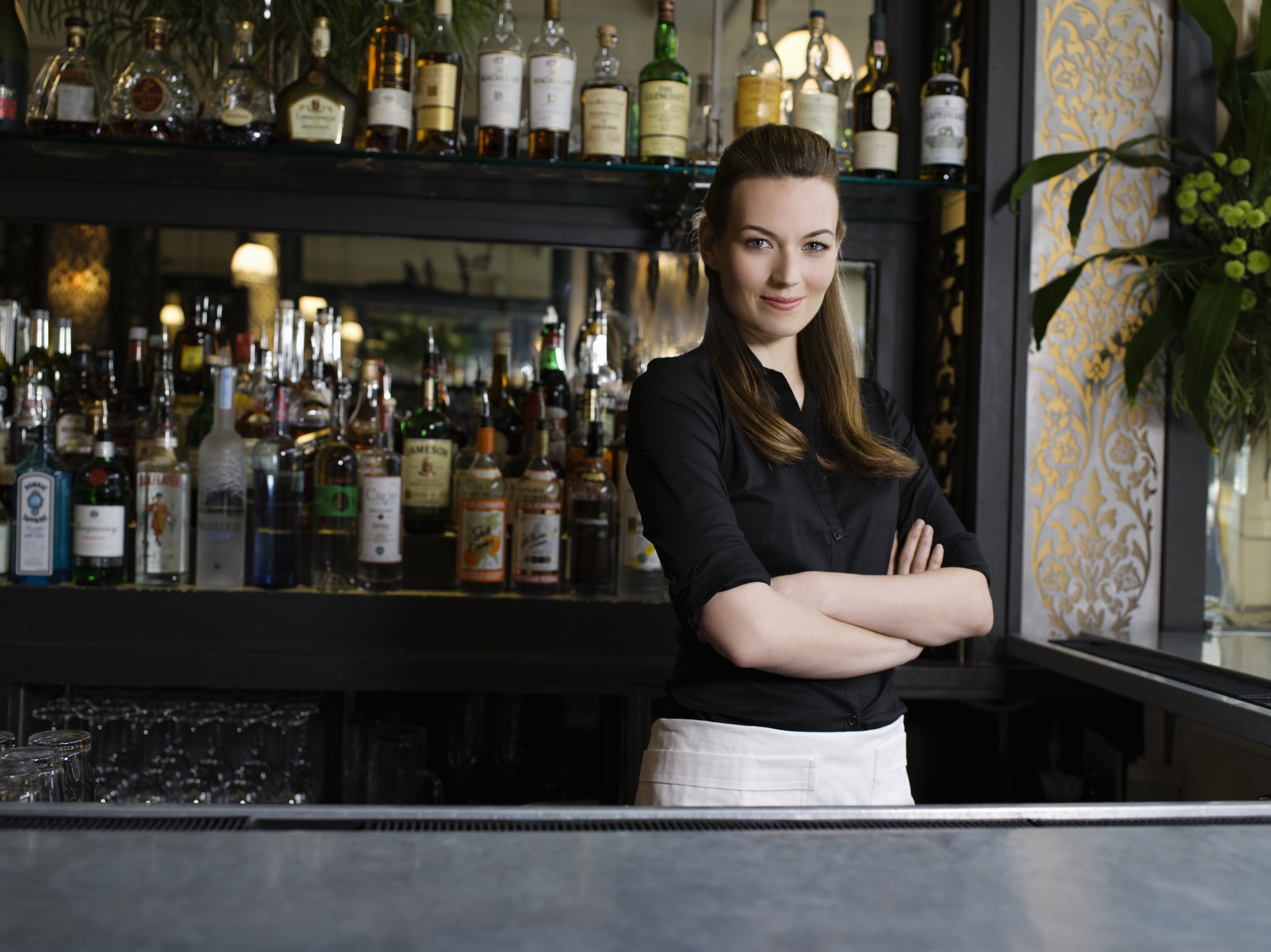 A confident female bartender standing behind the bar | Source: Getty Images