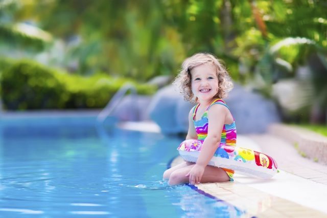 Niña sonriendo en una piscina. | Foto: Shutterstock