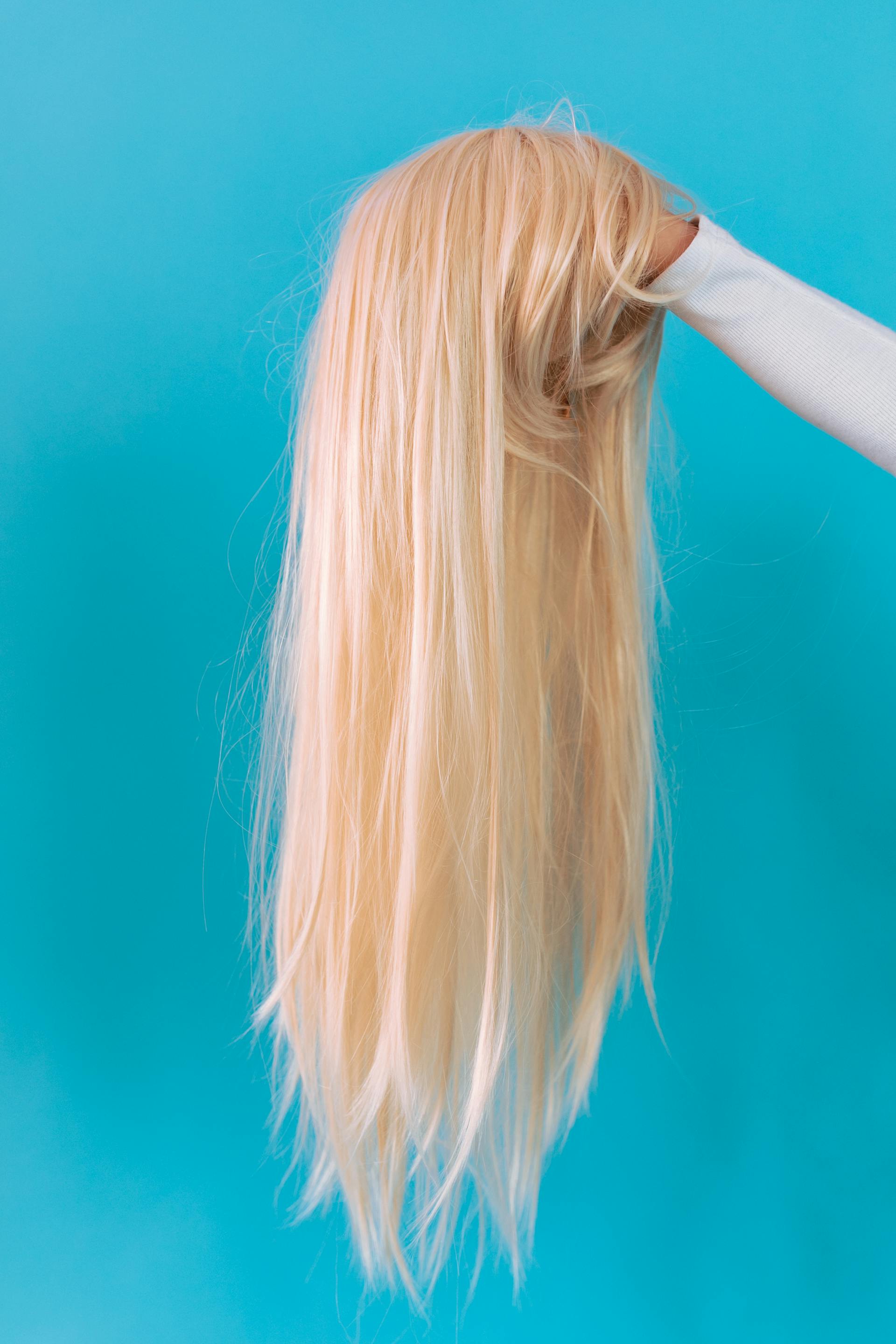 Woman holding a blonde wig | Source: Pexels