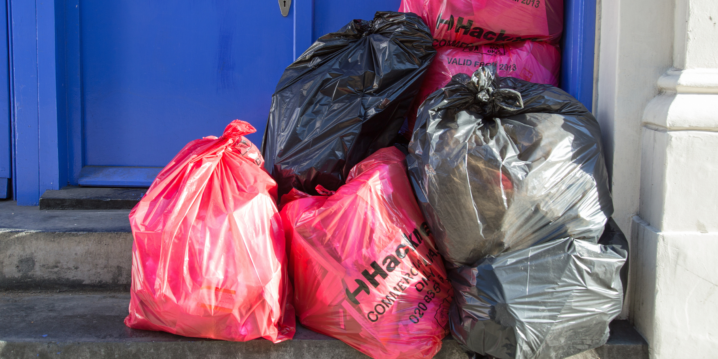 Garbage bags by door. | Source: Shutterstock