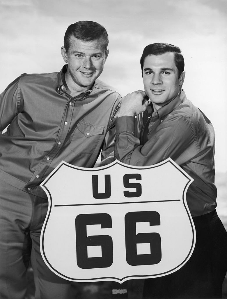 American actors Martin Milner (left) and George Maharis stand behind road sign for the television program, 'Route 66 | Source : Getty Images