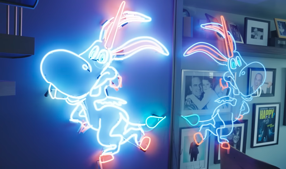 One of Christopher's former "co-stars" now glows permanently inside the apartment. The neon "Happy!" figure is part career memorabilia, part artwork and impossible to overlook. | Source: YouTube/Architectural Digest