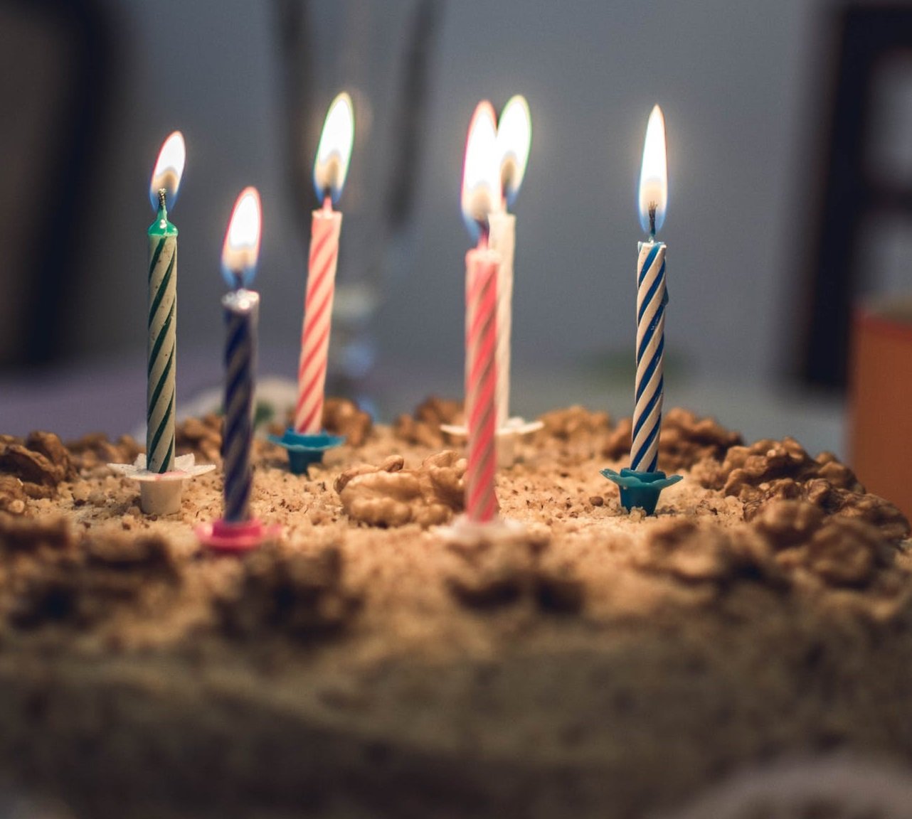 Pastel de cumpleaños con varias velas encendidas. | Foto: Pexels