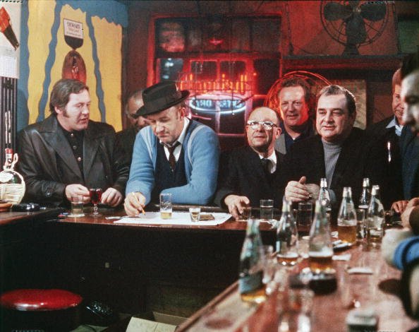 Gene Hackman prend des notes dans un bar dans une photo du film "The French Connection", réalisé par William Friedkin en 1971. | Photo : Getty Images Gene Hackman prend des notes dans un bar dans une photo du film "The French Connection", réalisé par William Friedkin en 1971. | Photo : Getty Images