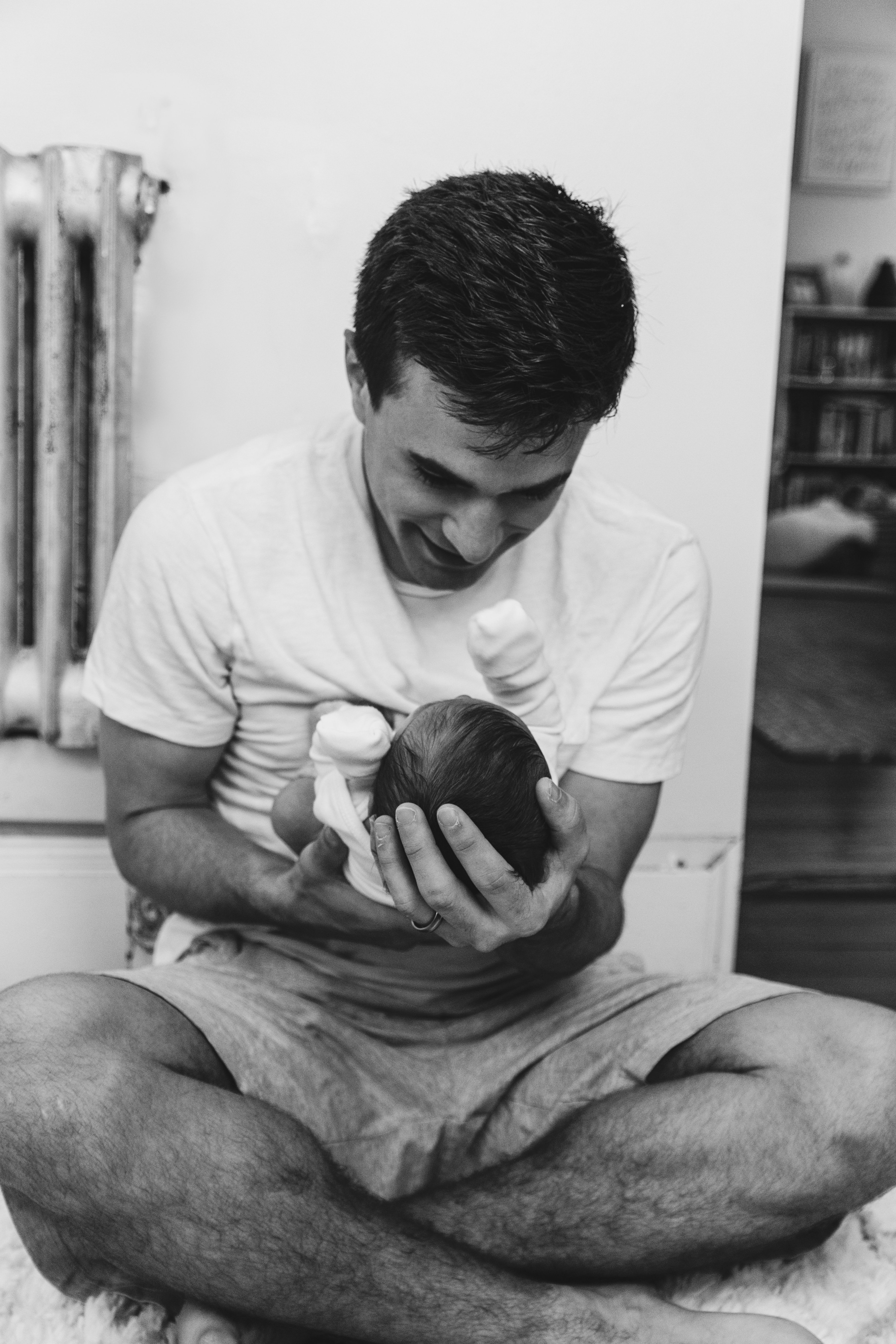 A young man looks down adoringly at the baby he is cuddling | Photo by Kelly Sikkema on Unsplash