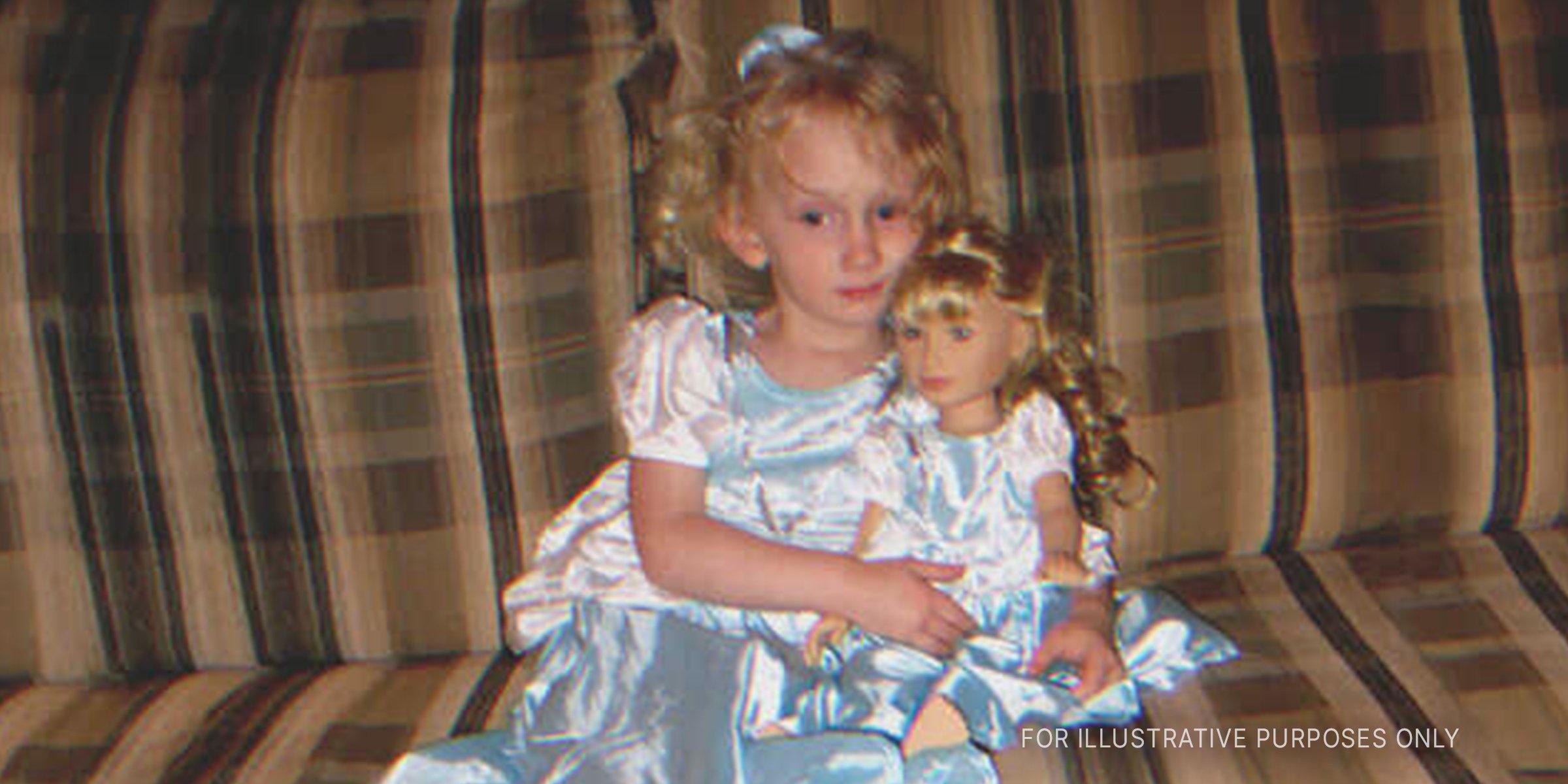 Little girl holding a doll on the couch. | Source: Flickr / Elizabeth/Table4Five (CC BY 2.0)