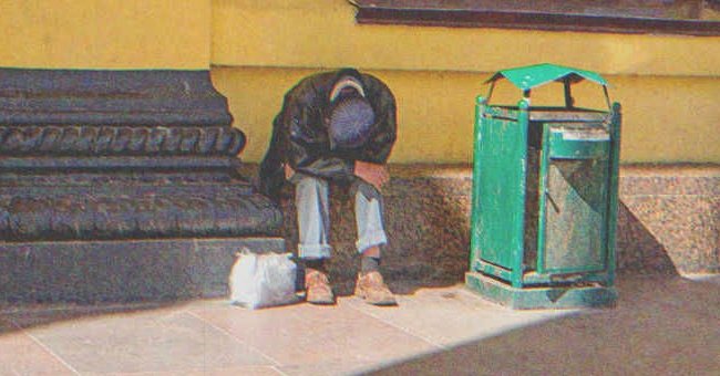 Un hombre sin hogar sentado frente a una pared mirando hacia el suelo. | Foto: Shutterstock