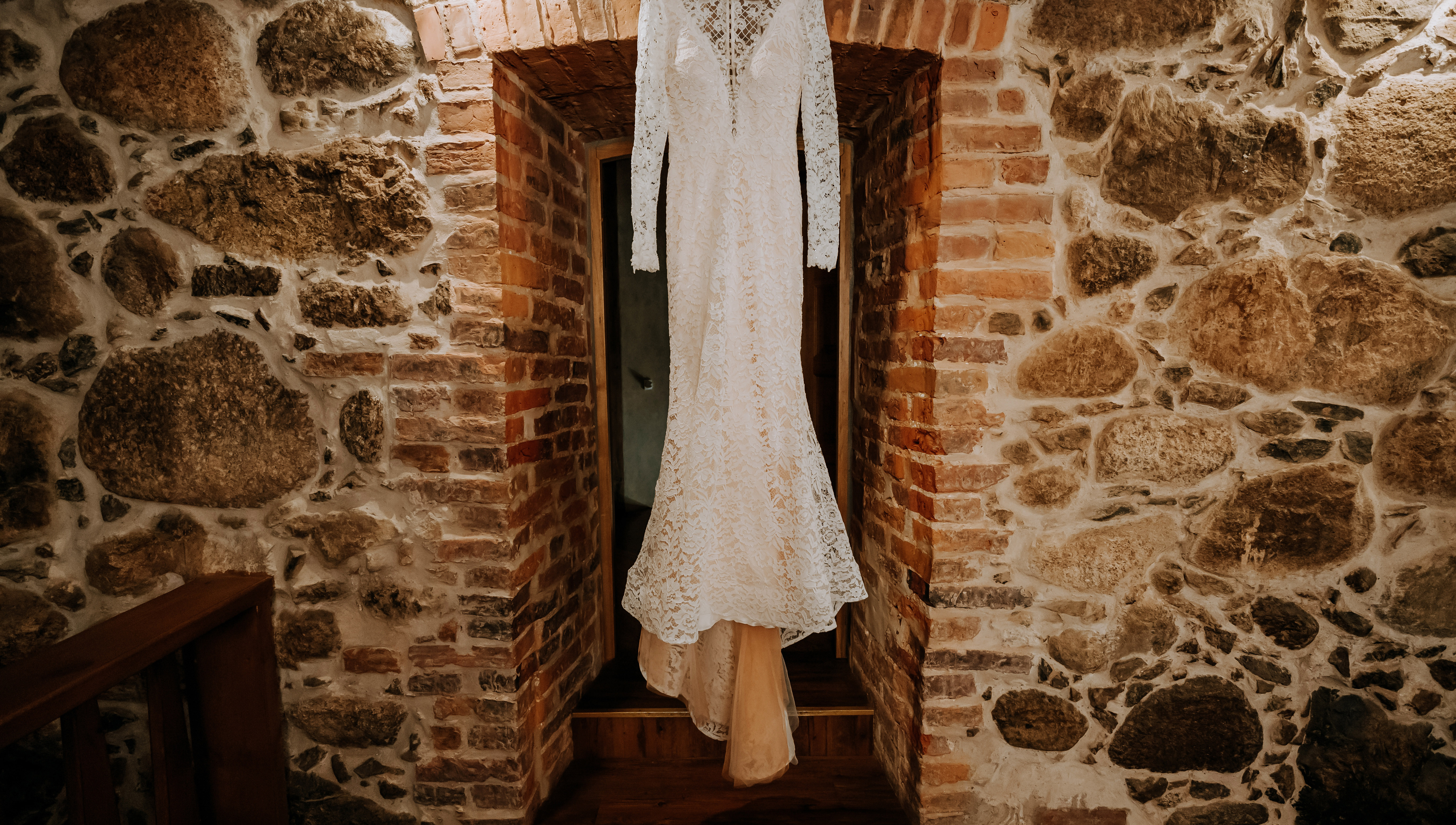 A wedding dress hanging in front of a stone wall | Source: Shutterstock