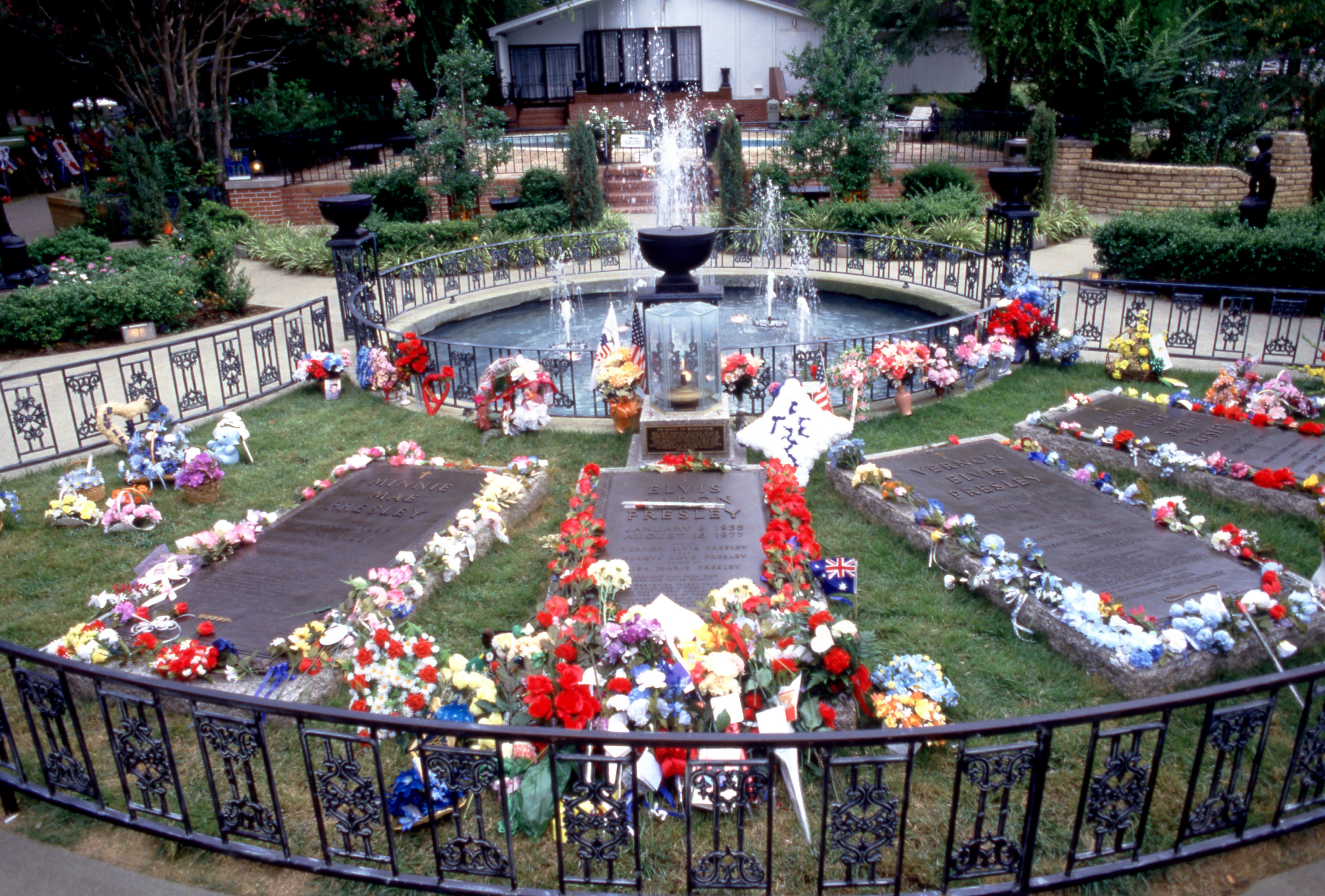 The headstones for Minnie Mae Presley, Elvis Aaron Presley, Vernon Elvis Presley and Gladys Love Smith Presley are surrounded with flowers, gifts, and decorations, prior to the 10th Anniversary of Elvis' death on August 15, 1987 at Graceland in Memphis, Tennessee | Source: Getty Images 