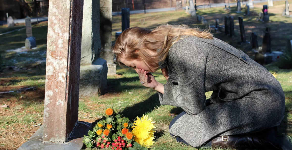 Woman grieving at the grave | Source: Shutterstock