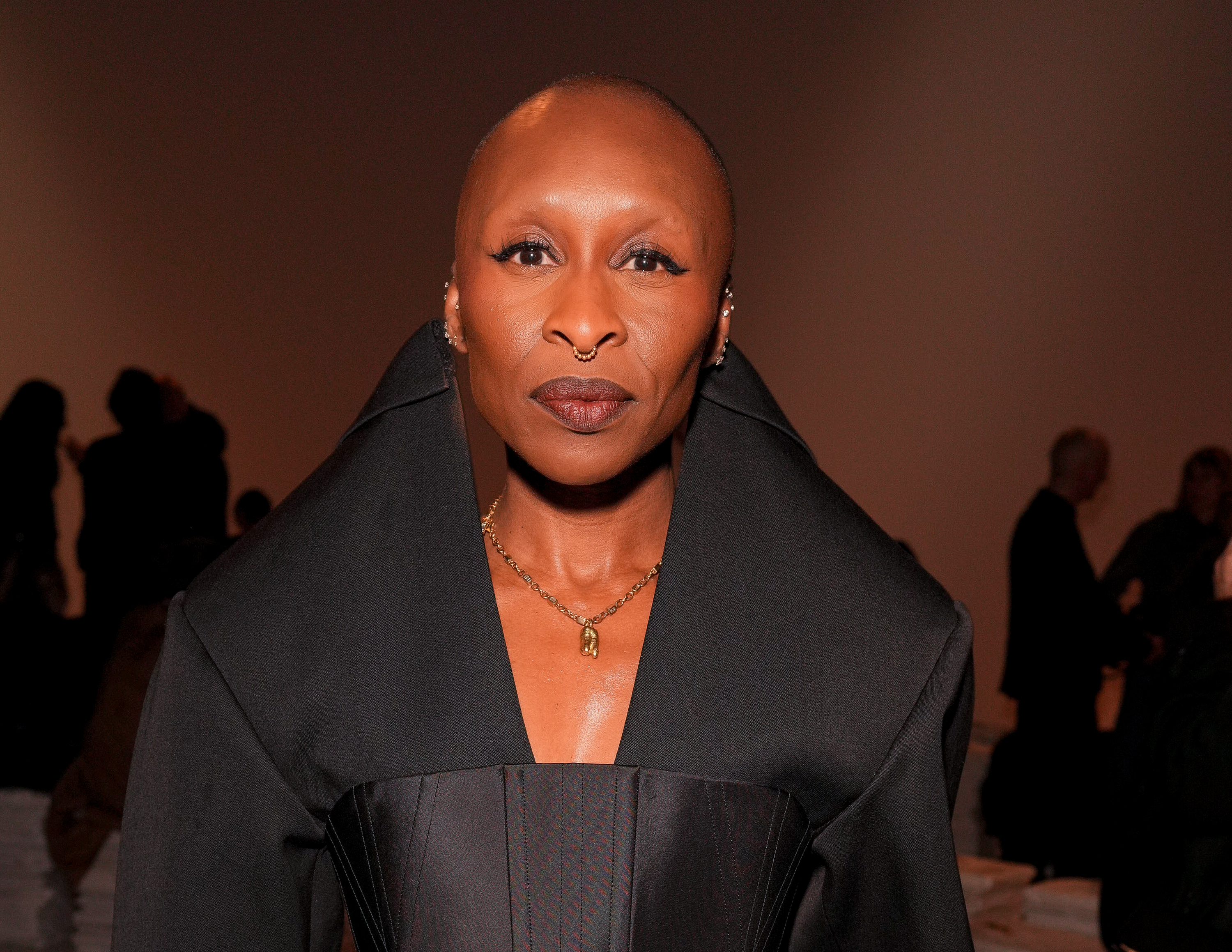 Erivo, also 38, made a commanding impression at the Givenchy show during Paris Fashion Week in a structured black coatdress with exaggerated shoulders. Her shaved head, bold eyeliner, and gleaming septum ring created a look that was striking and sculptural — projecting strength, intention, and high-fashion edge in every detail.