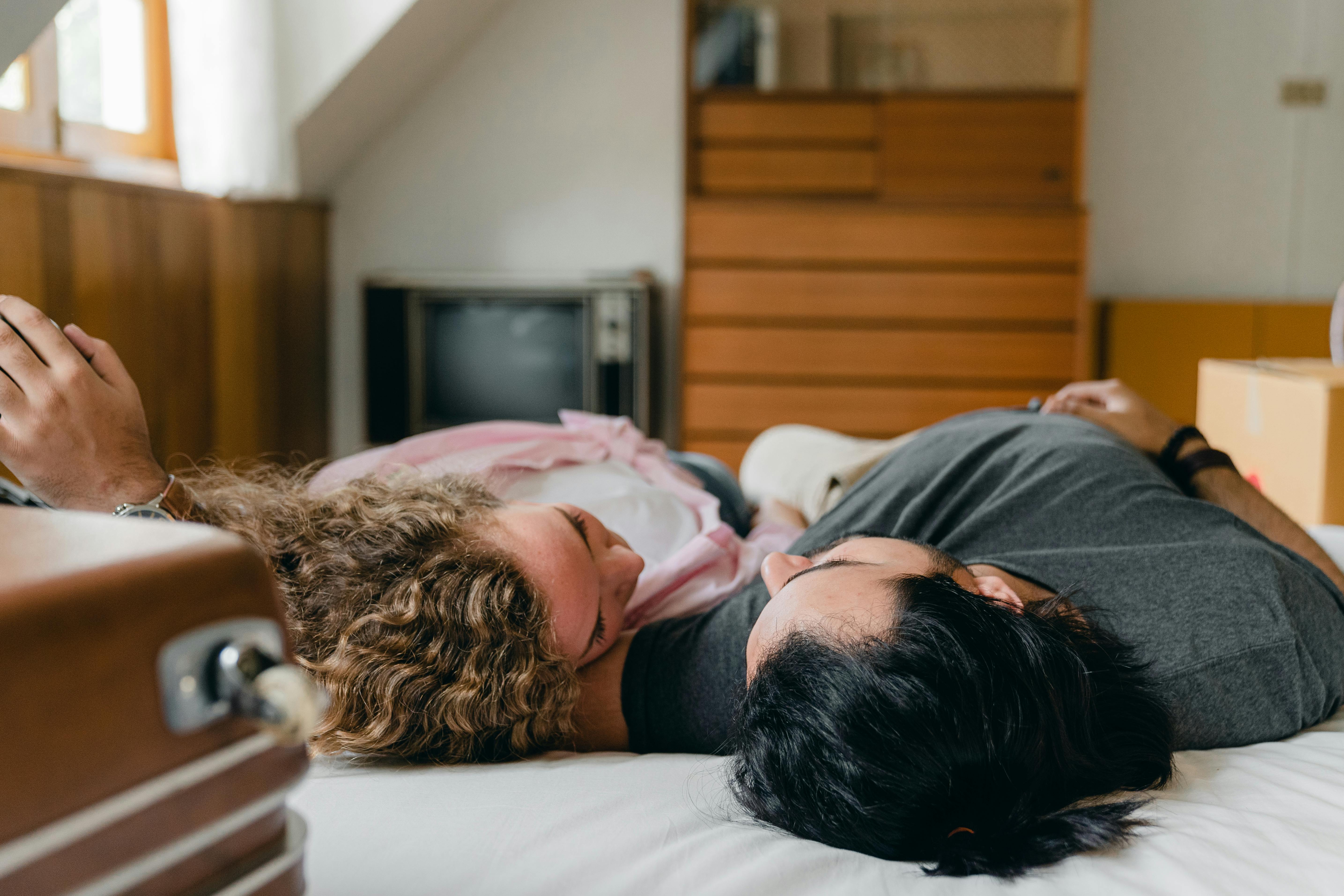 Couple lying together on the bed | Source: Pexels
