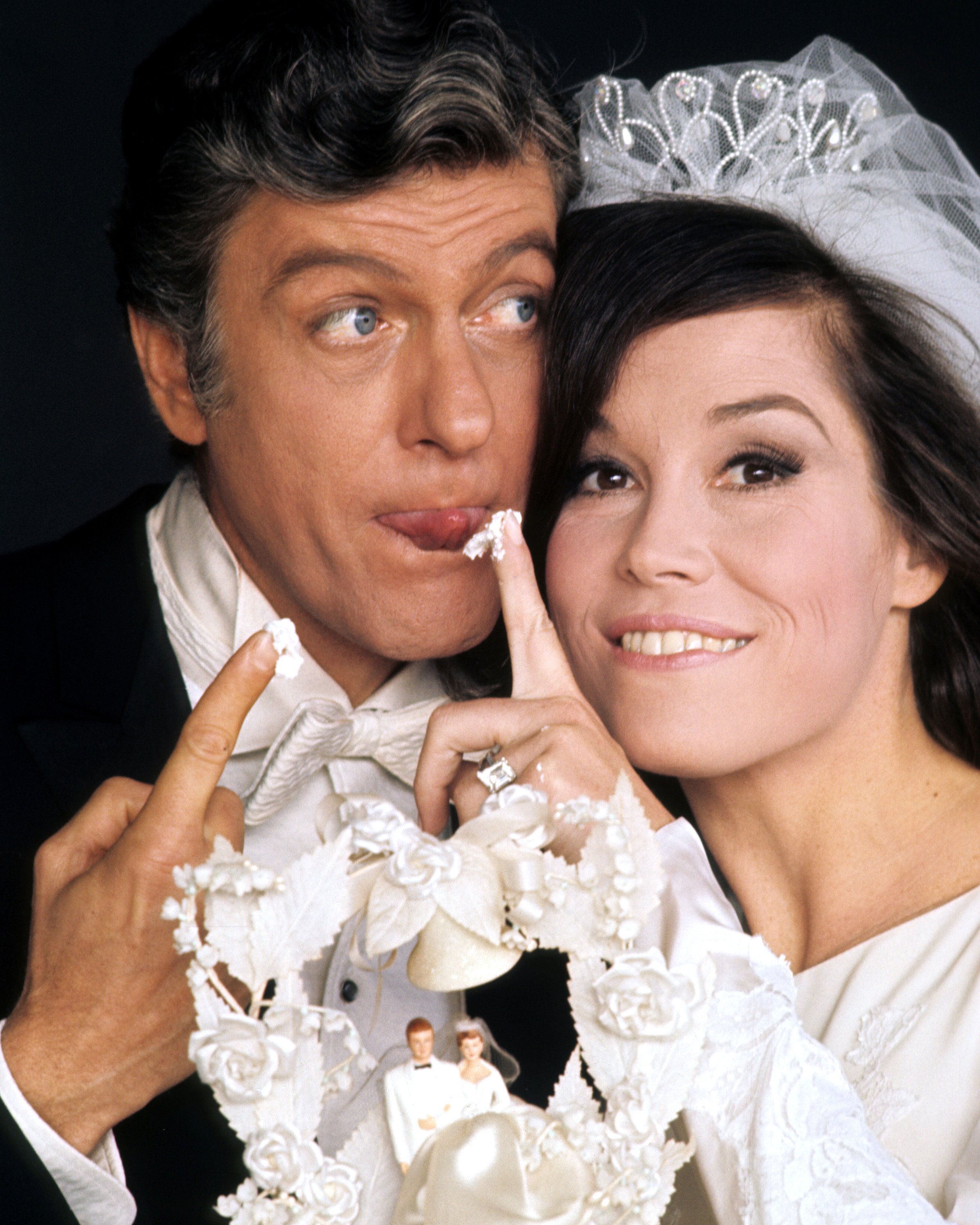 Dick Van Dyke, US actor, and Mary Tyler Moore, US actress, in a wedding dress, with a piece of icing from a wedding cake on her finger, in a publicity portrait issued for the US television special, 'Dick Van Dyke and the Other Woman', USA, 1969. | Source: Getty Images