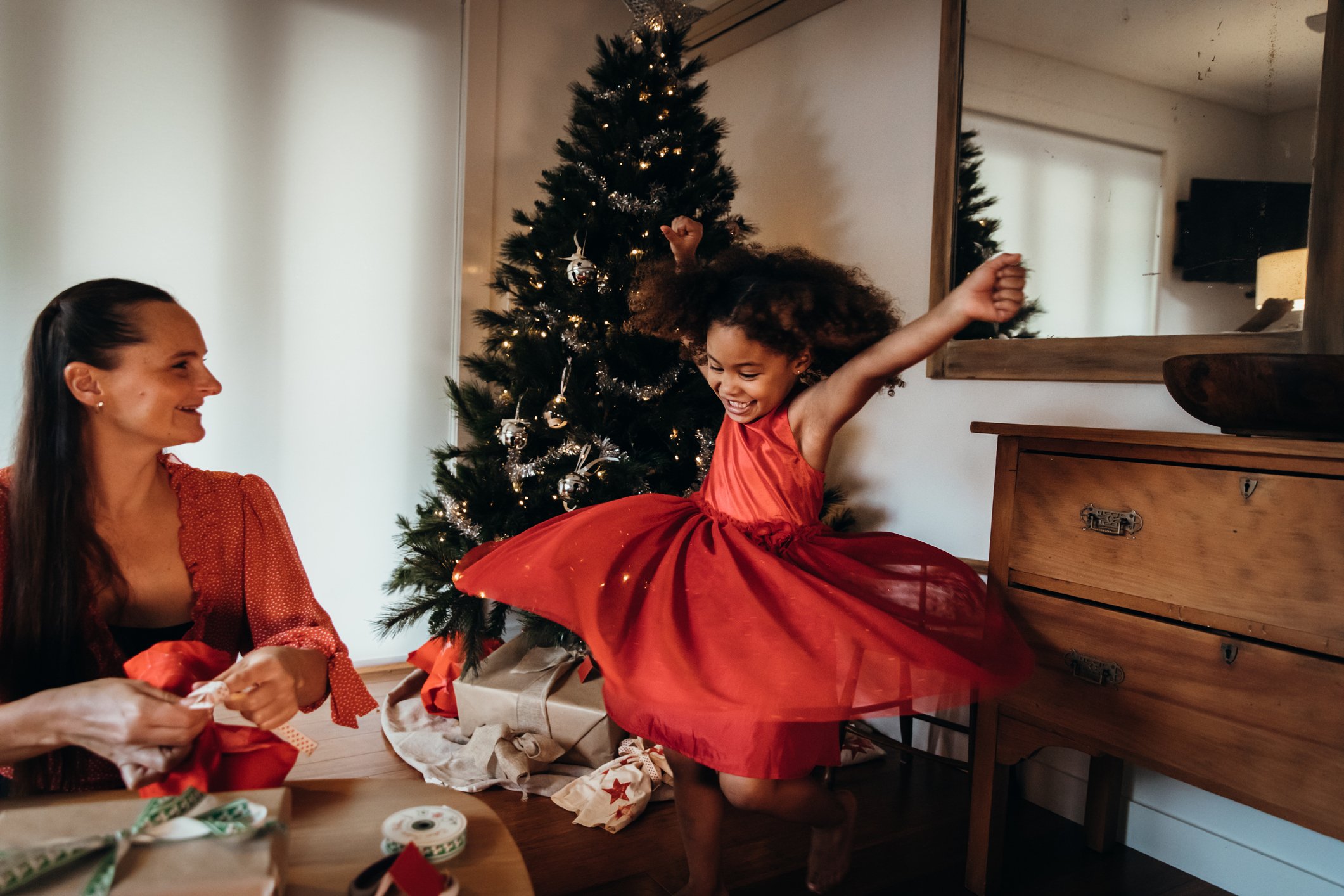 Kleines Mädchen tanzt im roten Heiligabendkleid I Quelle: Getty Images