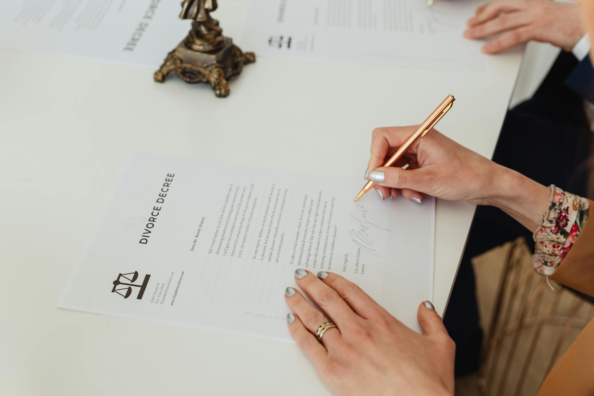 A closeup of a woman signing divorce papers | Source: Pexels