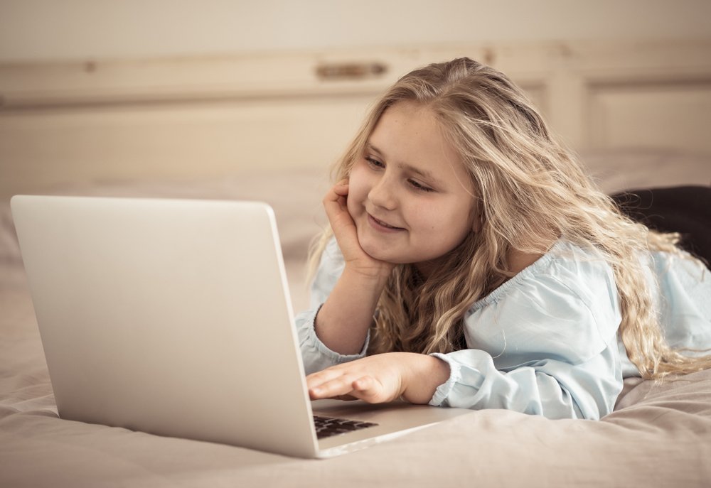 Young girl using a laptop in bed | Photo: Shutterstock Young girl using a laptop in bed | Photo: Shutterstock