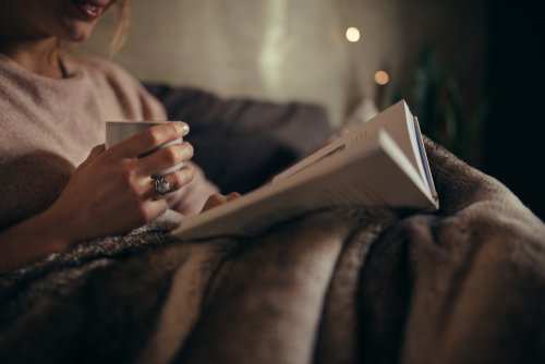 A woman reading a book in bed. | Source: Shutterstock.