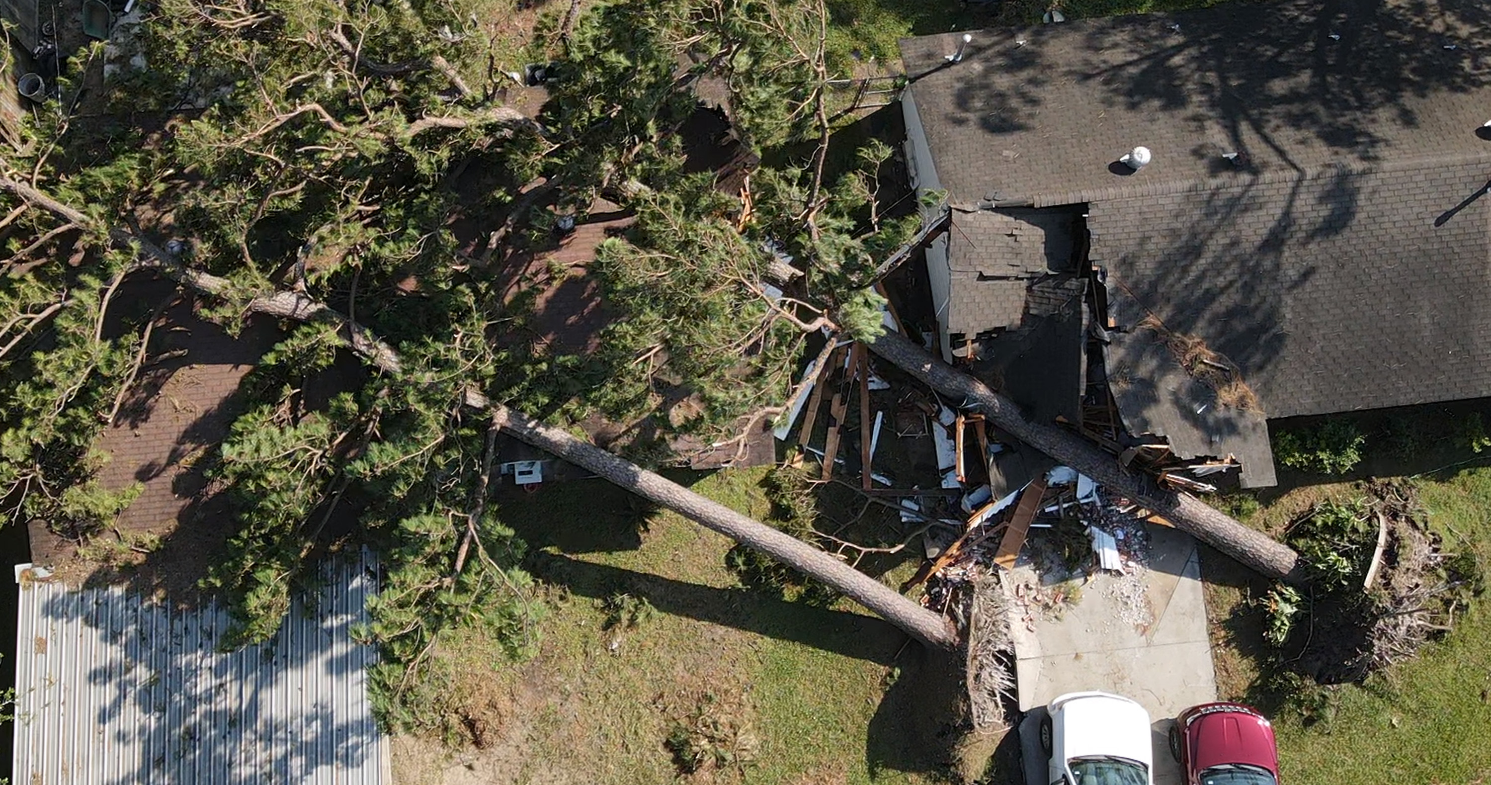 Trees that fell during Hurricane Beryl remain perched on a couple of houses in the Homestead neighborhood of Houston on July 10, 2024 | Source: Getty Images