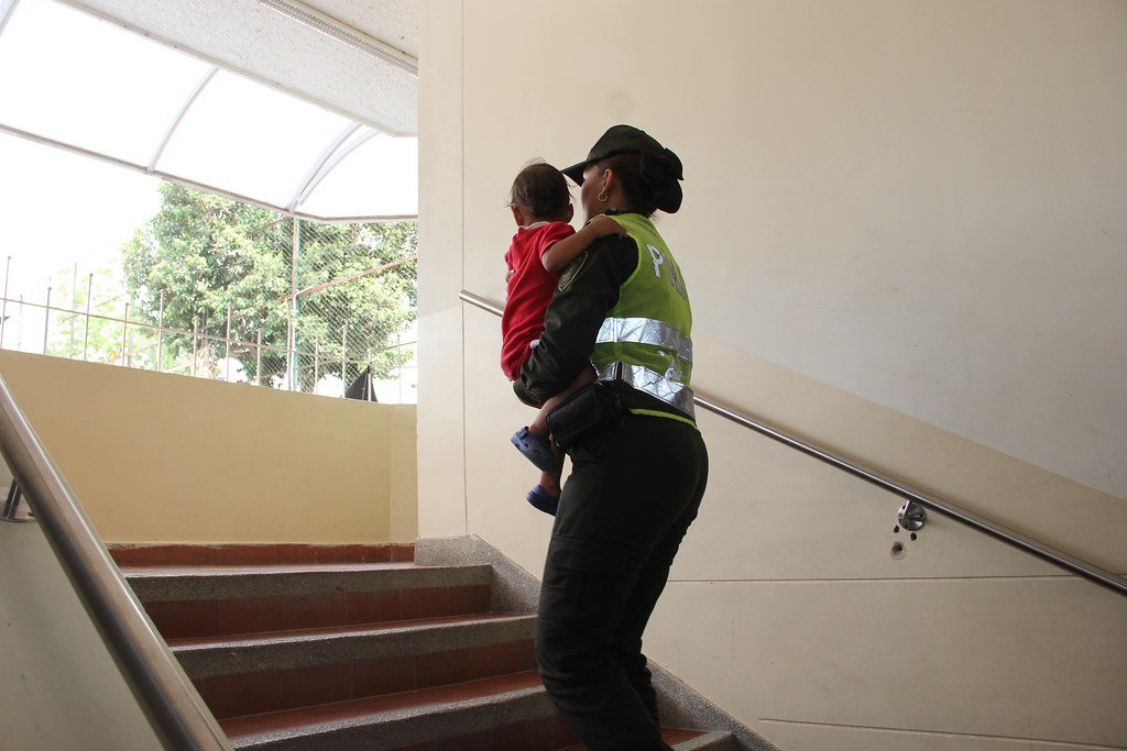 Policía sube escaleras con niño en sus brazos. | Foto Archivo: Flickr Policía sube escaleras con niño en sus brazos. | Foto Archivo: Flickr