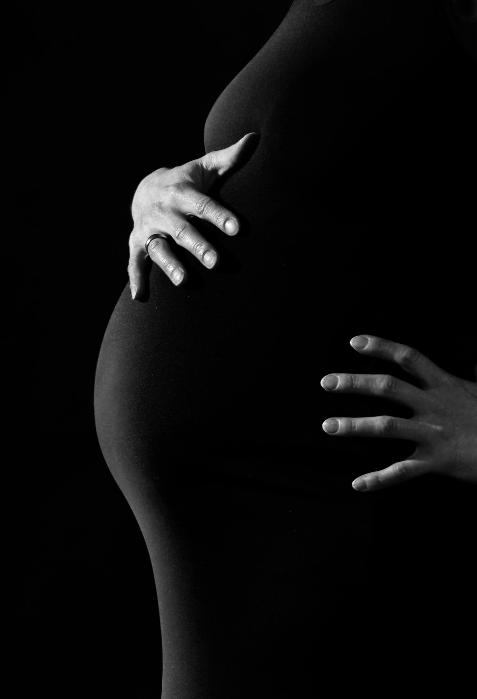 A black and white photo of a woman holding her pregnant belly | Source: Pixabay on Pexels