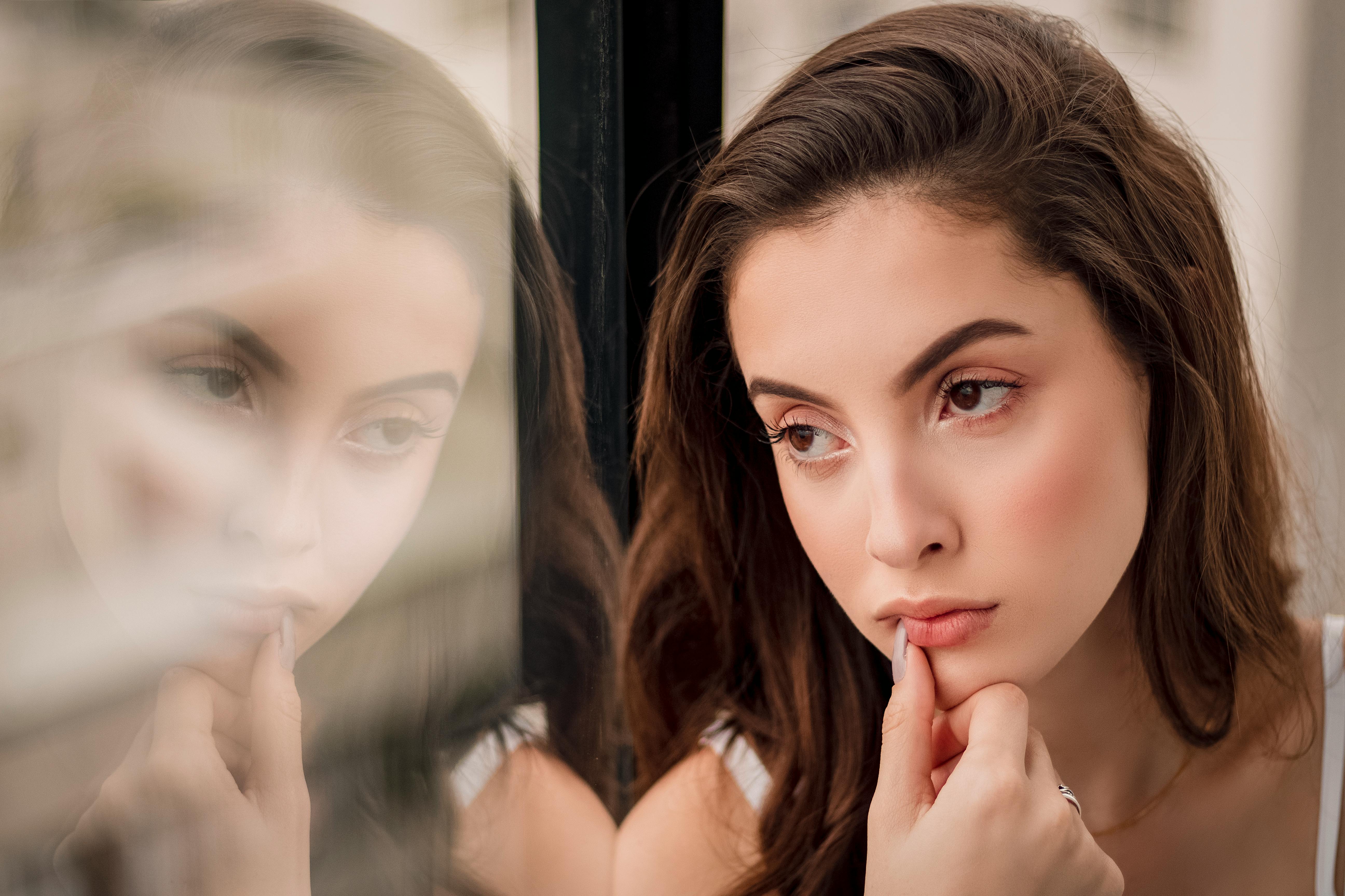 A woman lost in thought and looking out the window | Source: Pexels