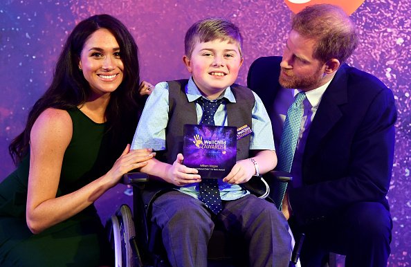 Le prince Harry, le duc de Sussex et Meghan, la duchesse de Sussex posent pour une photo avec le lauréat William Magee à l'occasion du WellChild Awards | Photo: Getty Images Le prince Harry, le duc de Sussex et Meghan, la duchesse de Sussex posent pour une photo avec le lauréat William Magee à l'occasion du WellChild Awards | Photo: Getty Images