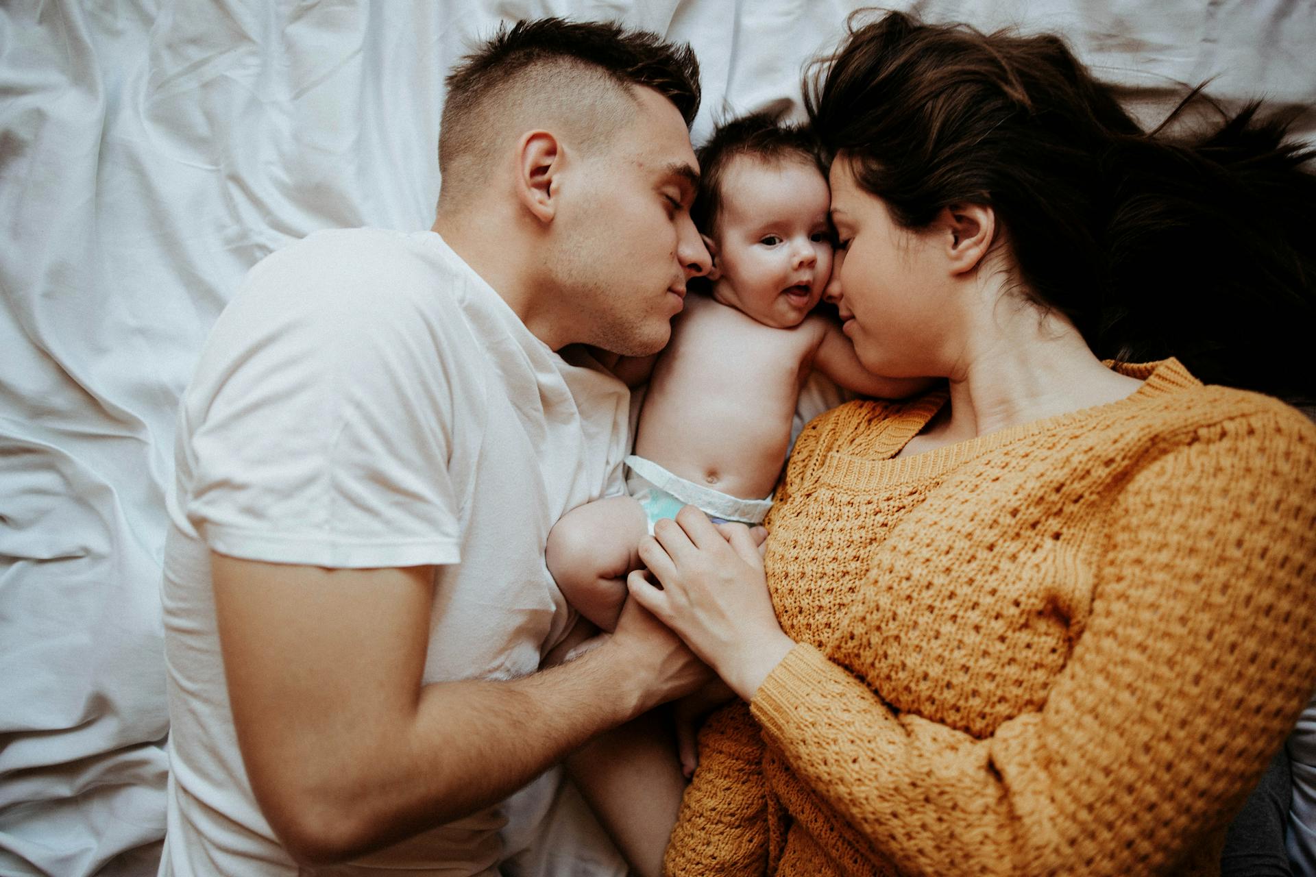 A couple in bed with a baby | Source: Pexels