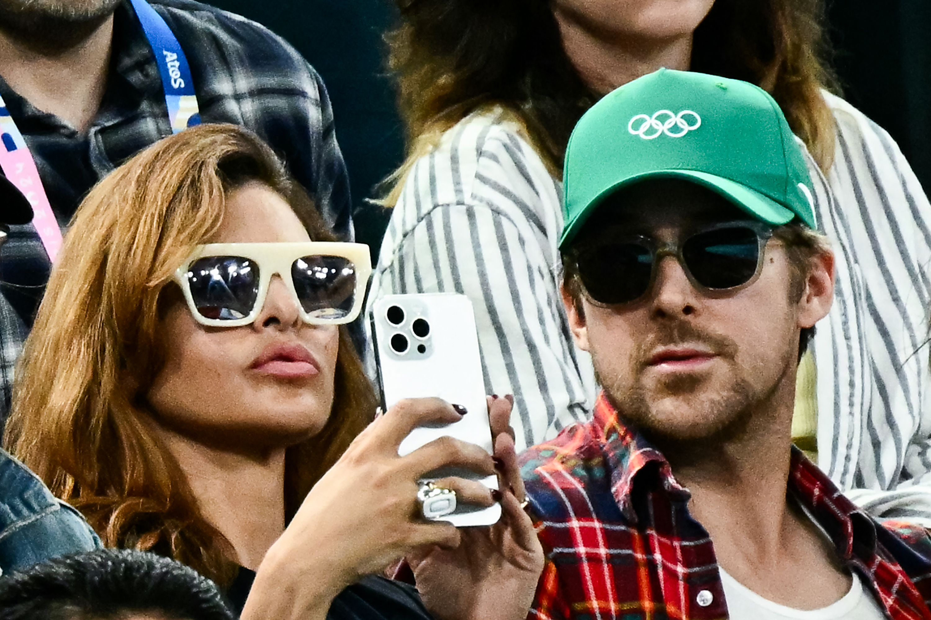 Eva Mendes holding her phone next to Ryan Gosling while watching the women’s uneven bars final at the Bercy Arena during the 2024 Paris Olympics on August 4, 2024 | Source: Getty Images