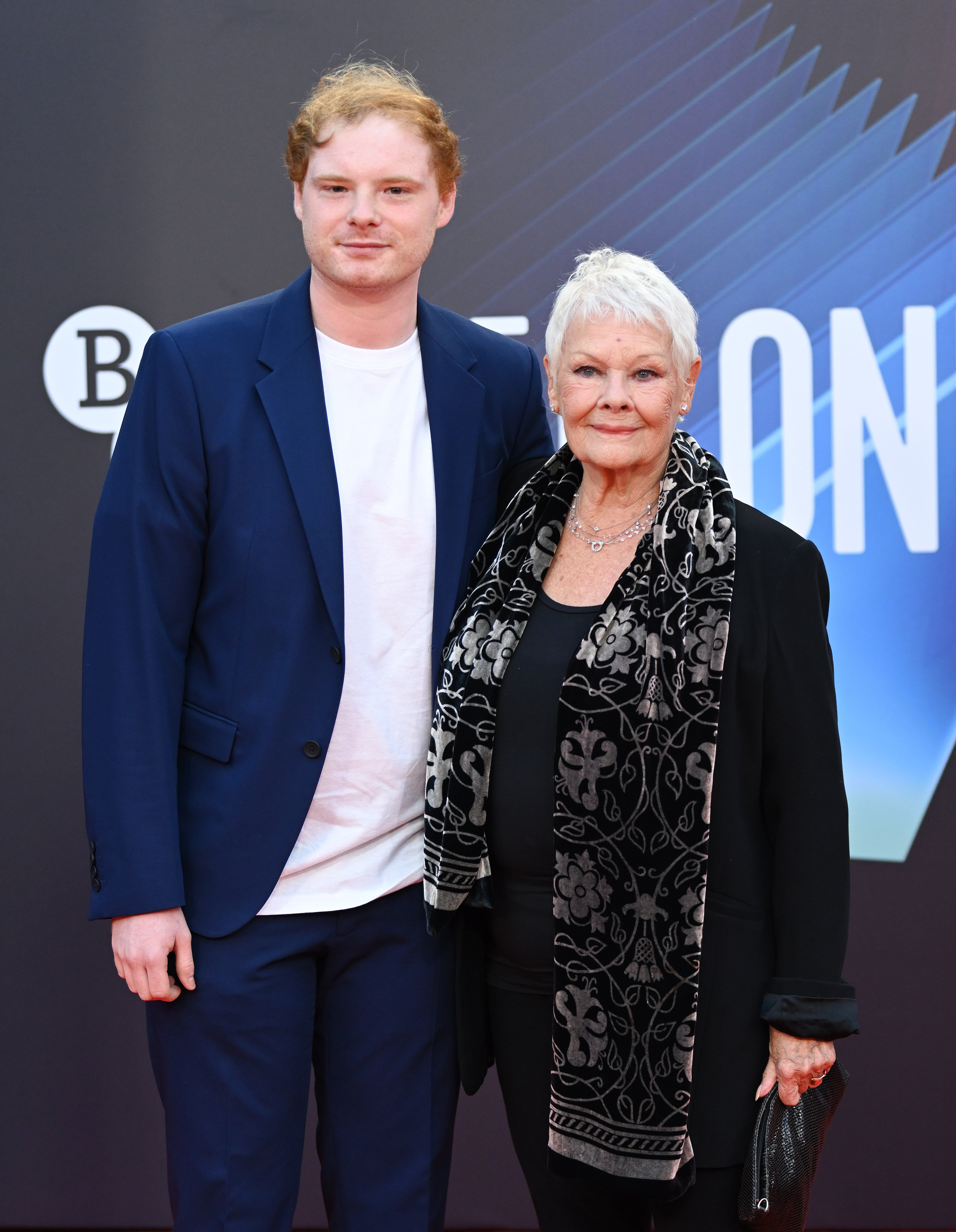 Judi Dench and Sam WIlliams attend the "Belfast" European Premiere during the 65th BFI London Film Festival at The Royal Festival Hall on October 12, 2021 in London, England ┃Source: Getty Images