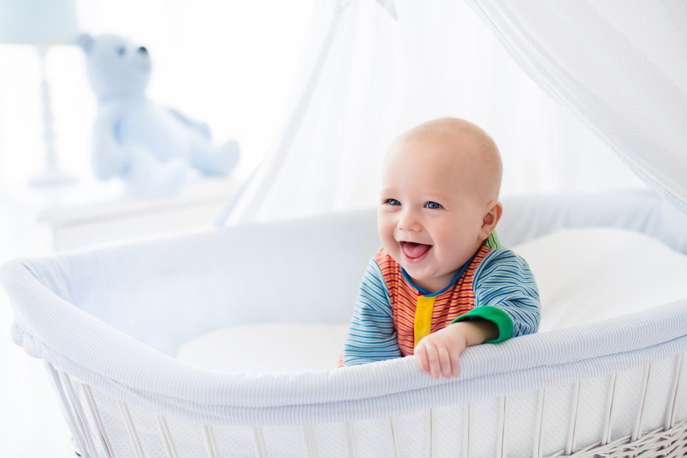 Un bébé qui sourie dans un berceau | Photo : Shutterstock
