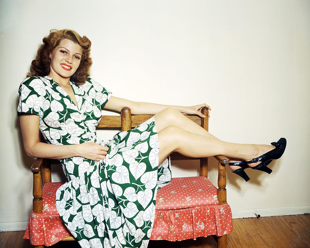 Rita Hayworth (1918 - 1987) wearing a green and white, leaf-patterned dress and putting her feet up, circa 1945. | Source: Getty Images