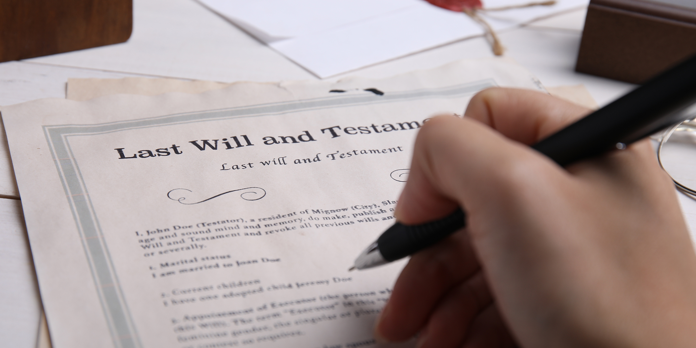 A person holding a pen over a will | Source: Shutterstock