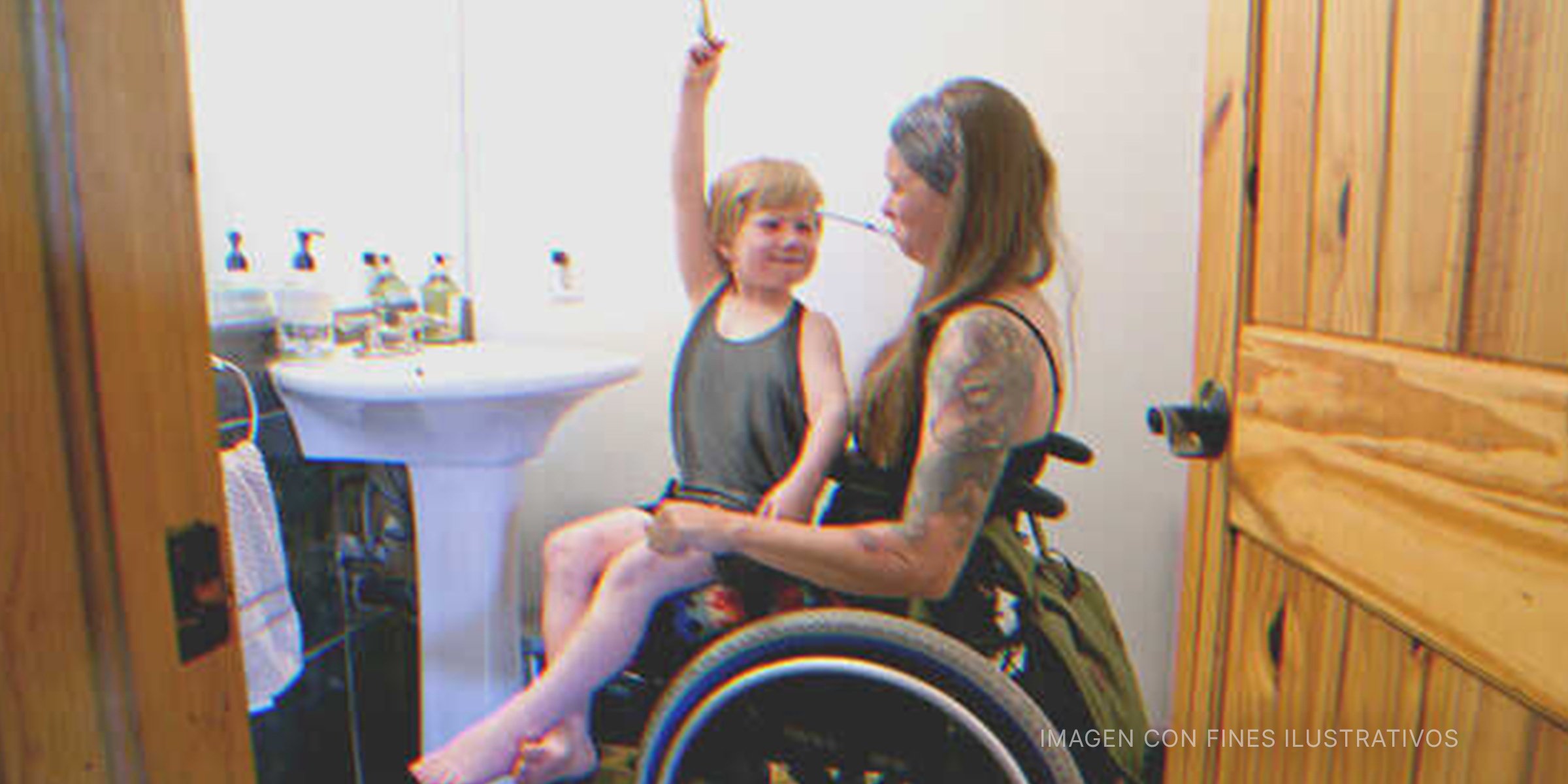 Mujer en silla de ruedas con niño en sus piernas | Foto: Getty Images