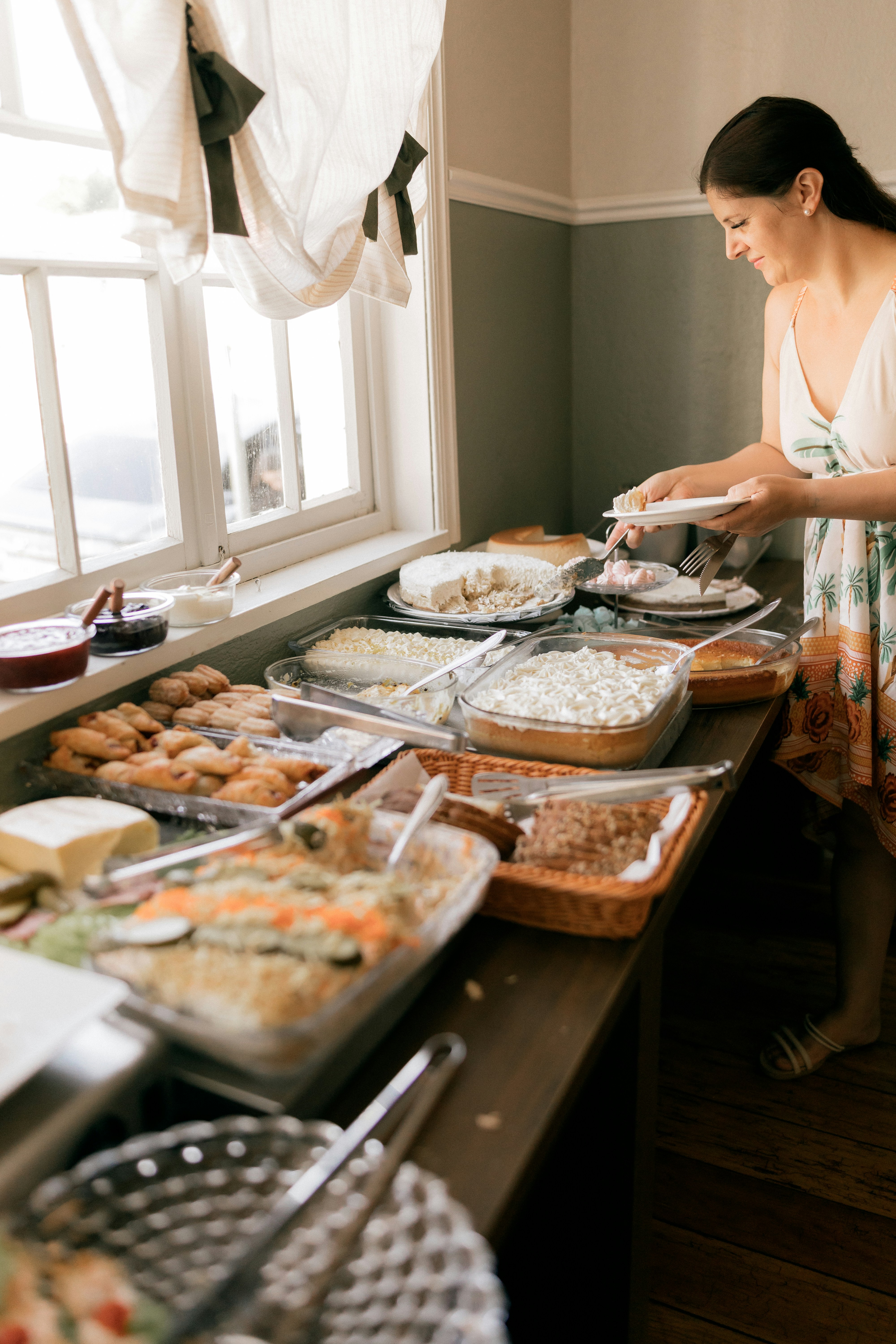 Woman getting food from a buffet of dishes | Source: Unsplash