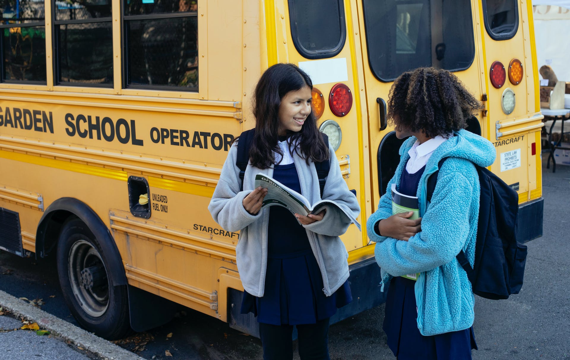 Students standing beside a school bus | Source: Pexels