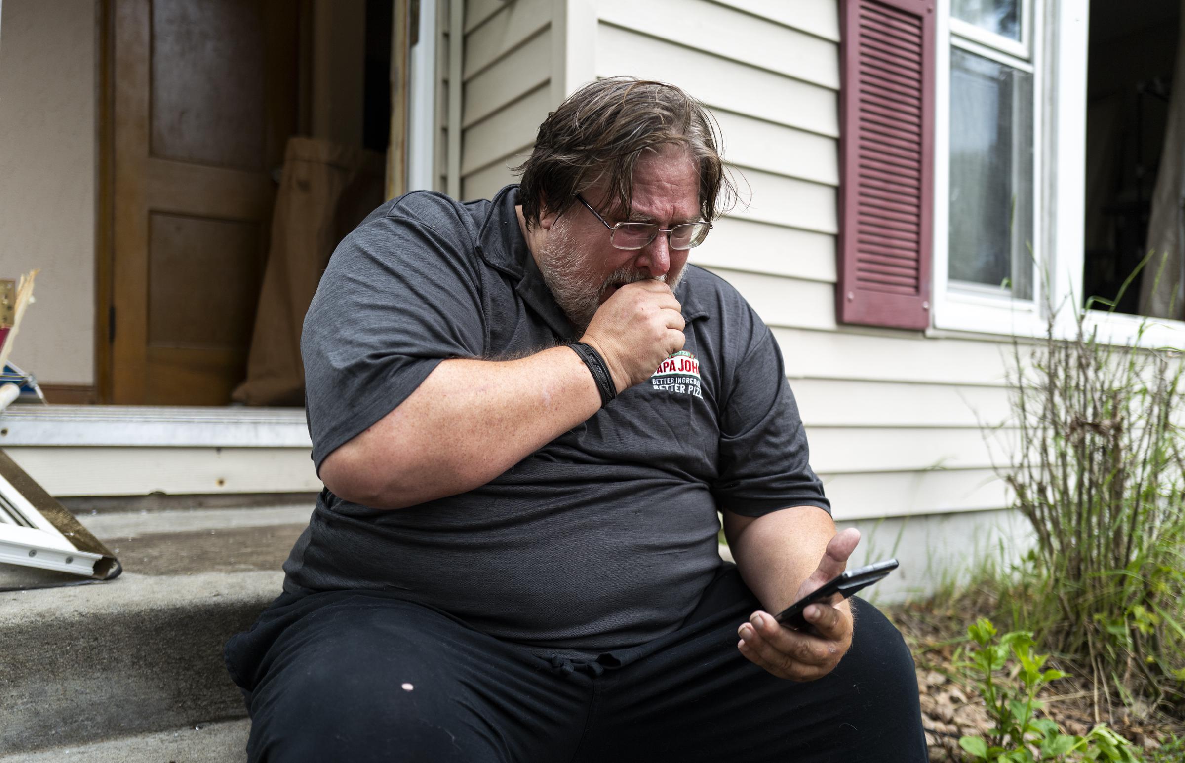 Daniel Carlson reads a text message he received this morning outside his home on June 14, 2025 in Minneapolis, Minnesota | Source: Getty Images